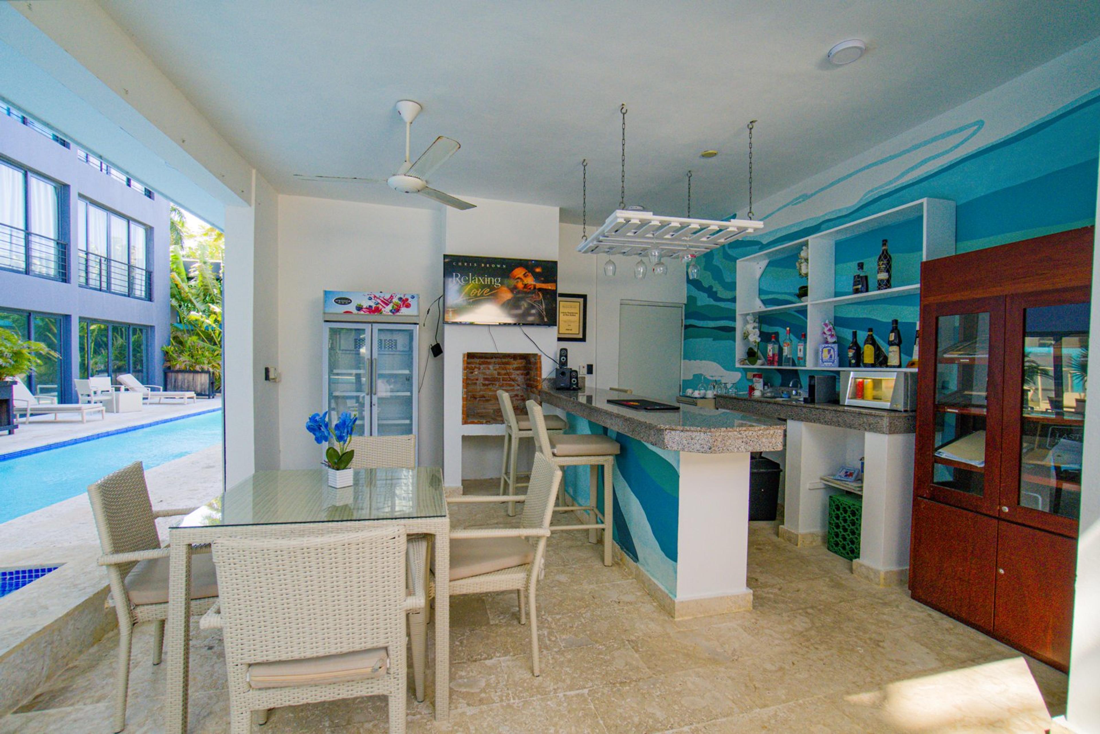 Open poolside bar and seating area with turquoise walls