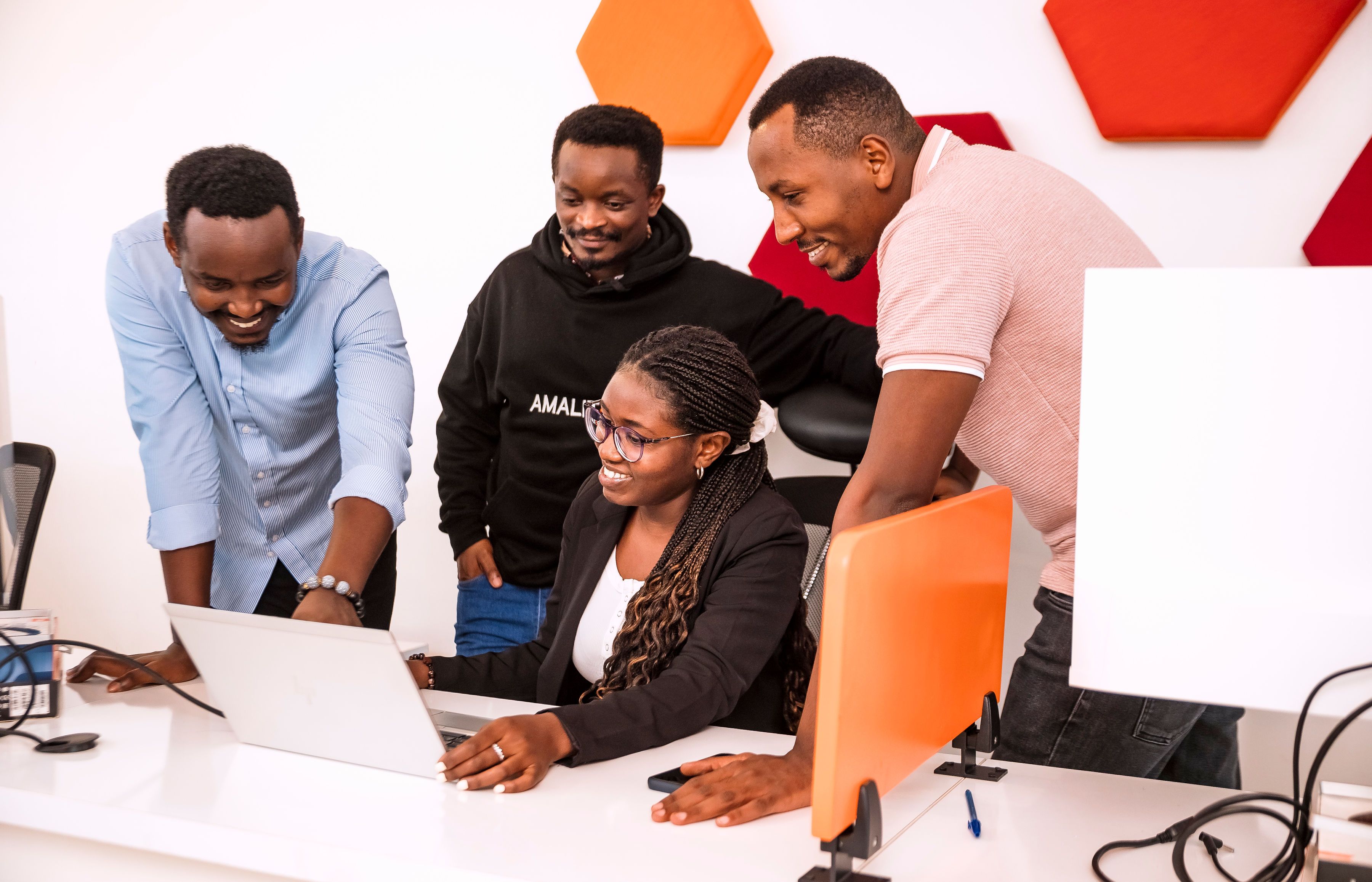 A team gathered around a laptop, smiling and in conversation