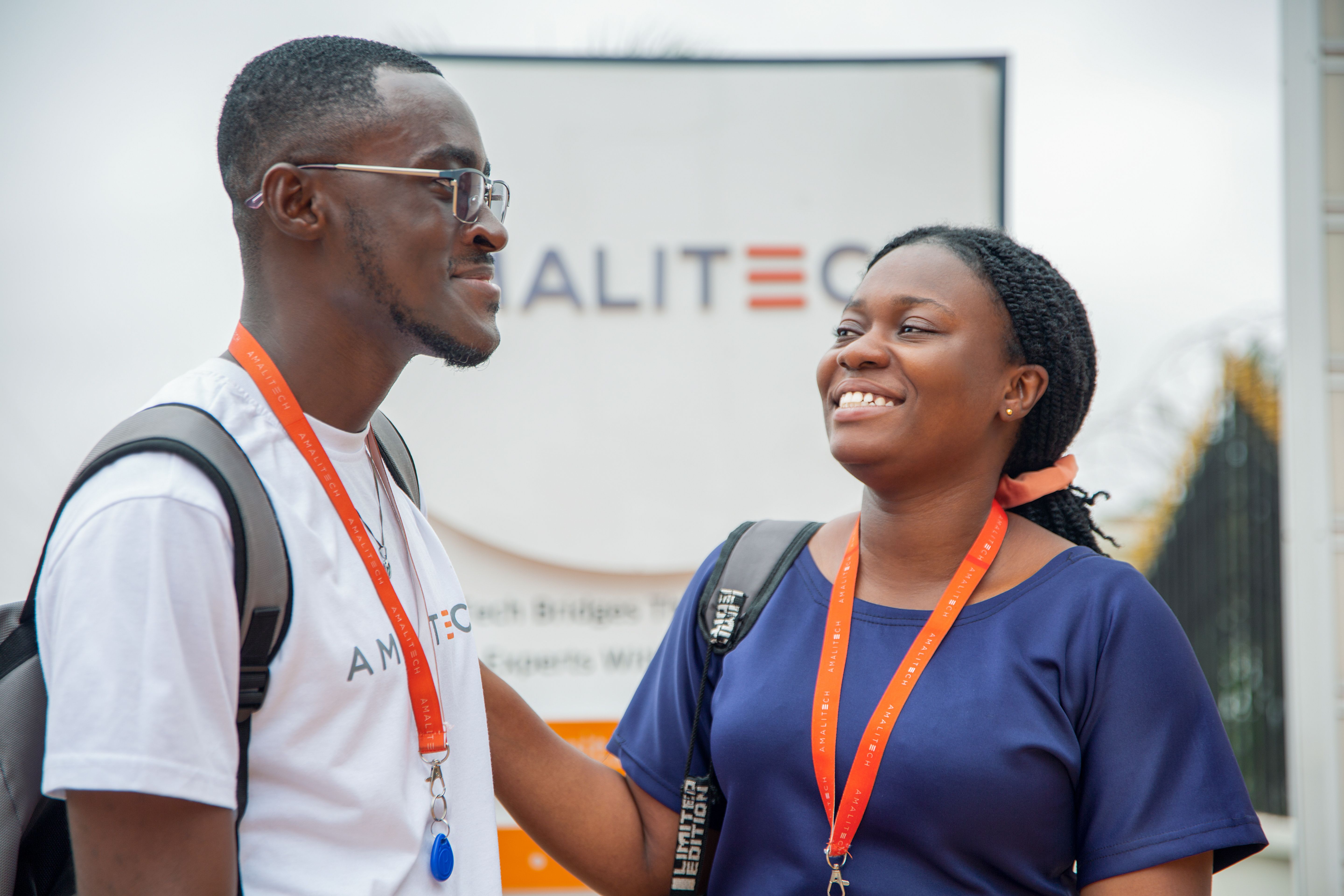 Two people standing next to each other, smiling at each other