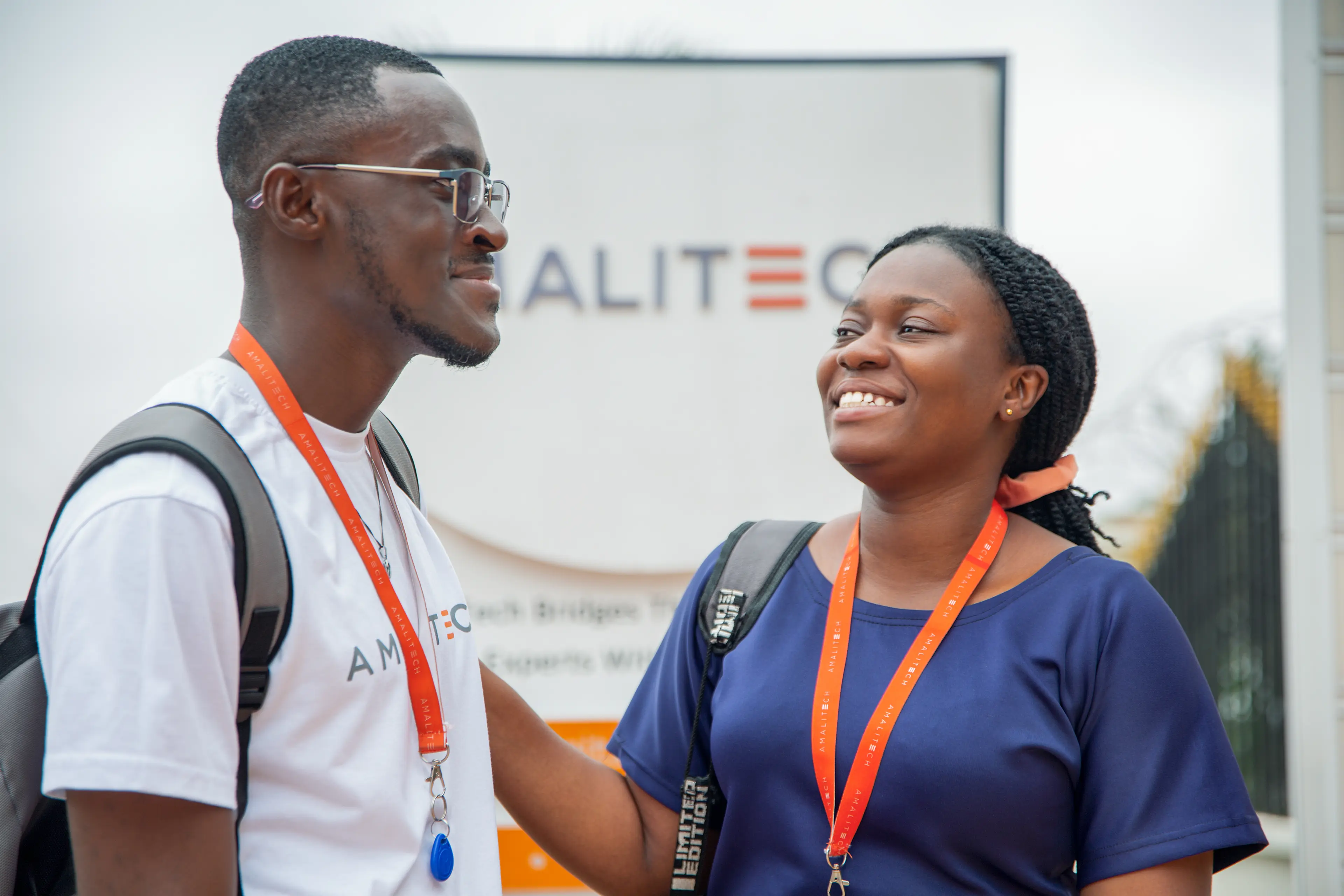 Two people standing next to each other, smiling at each other
