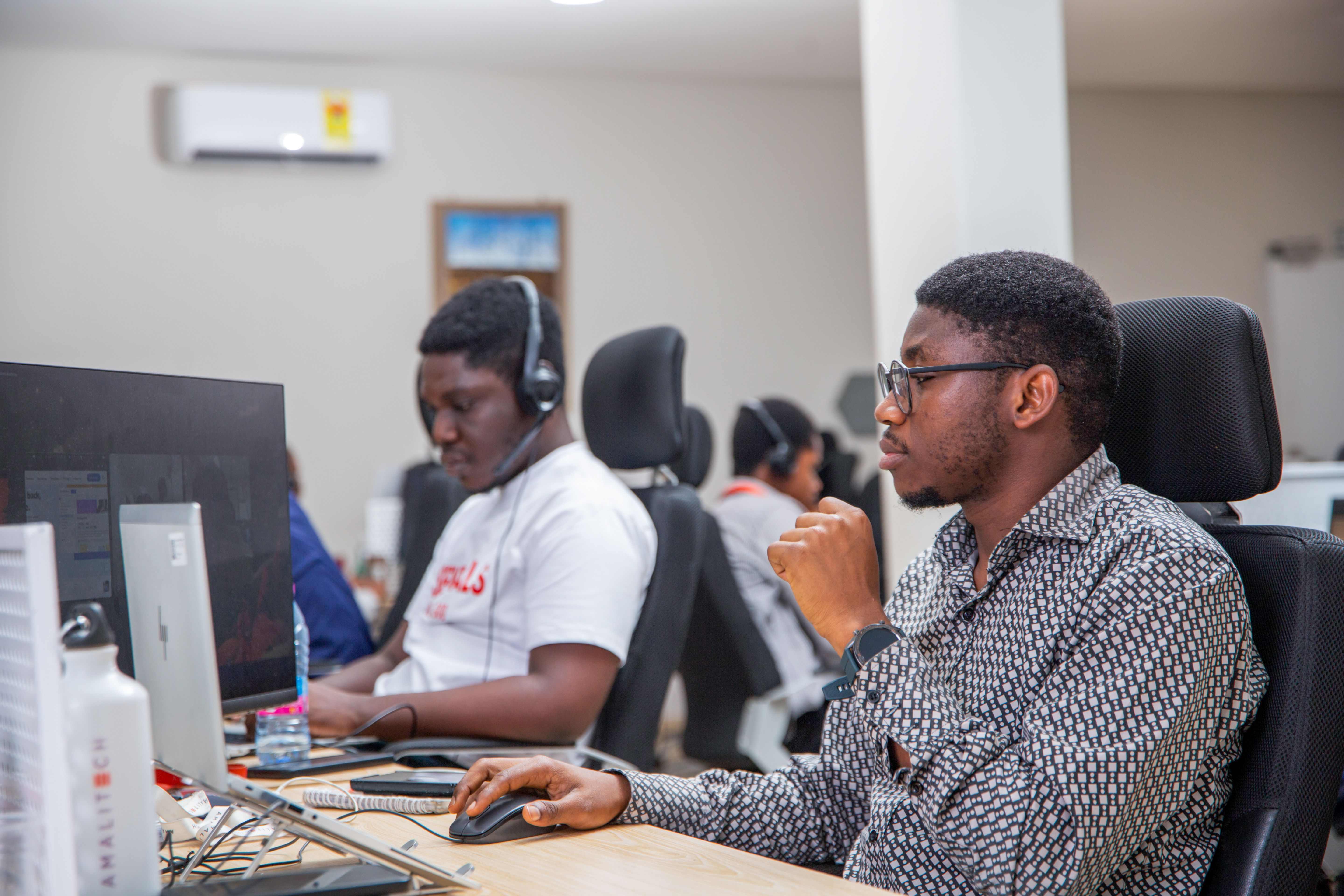 Two men sitting at desk, working on their computers