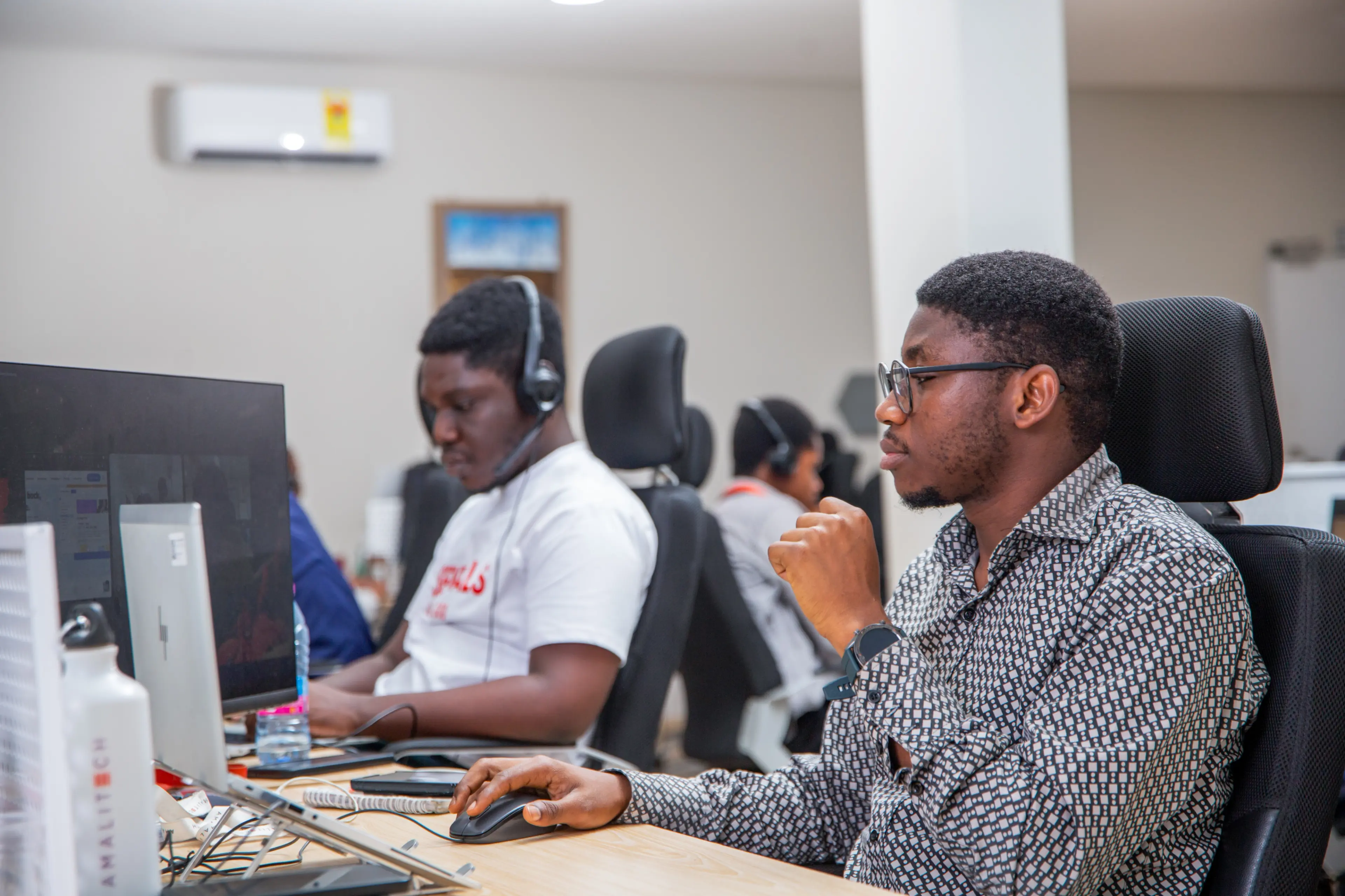 Two men sitting at desk, working on their computers