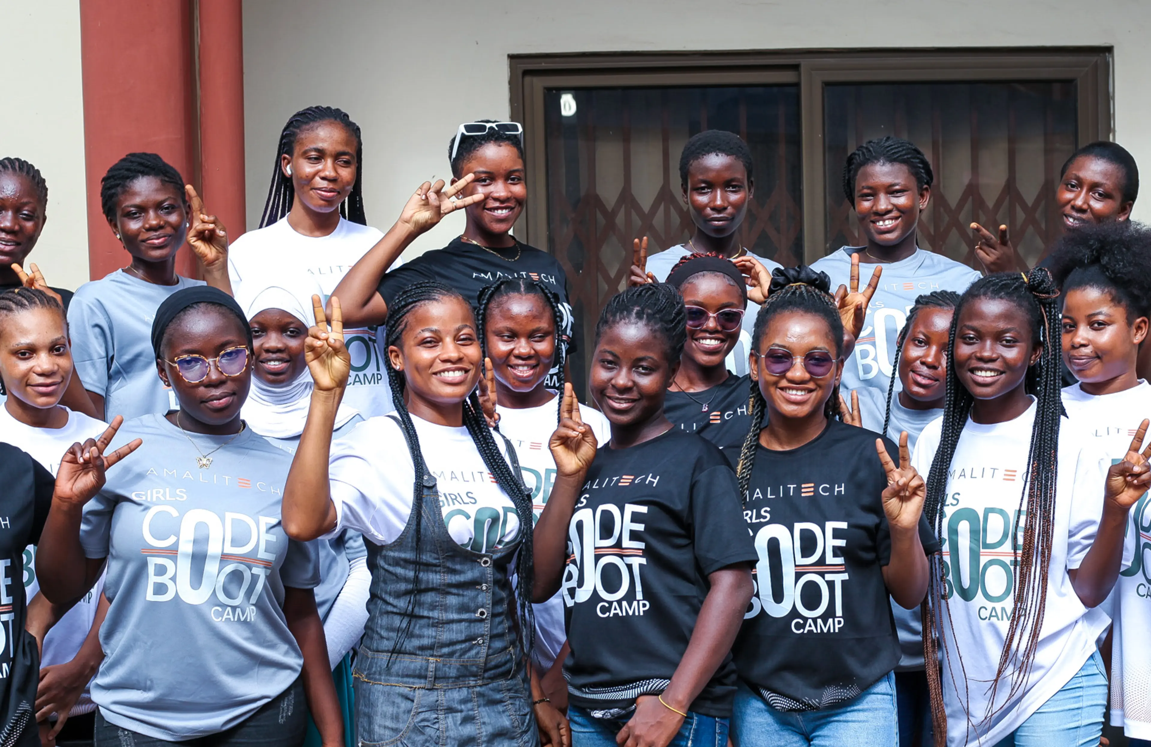 a group of women wearing "Girls Code Boocamp" tshirts, standing next to each other, smiling at the camera