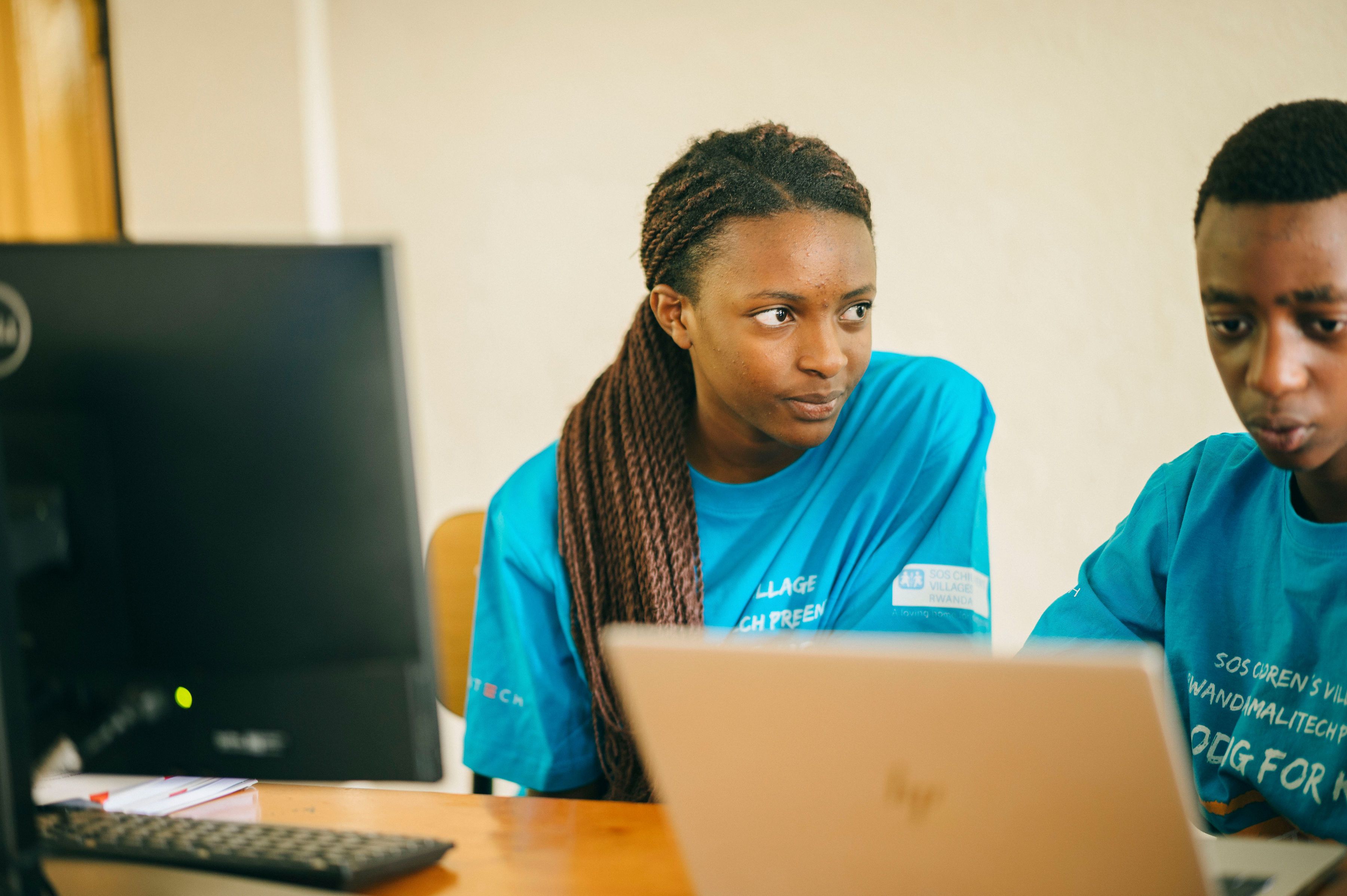 Two kids looking at a laptop