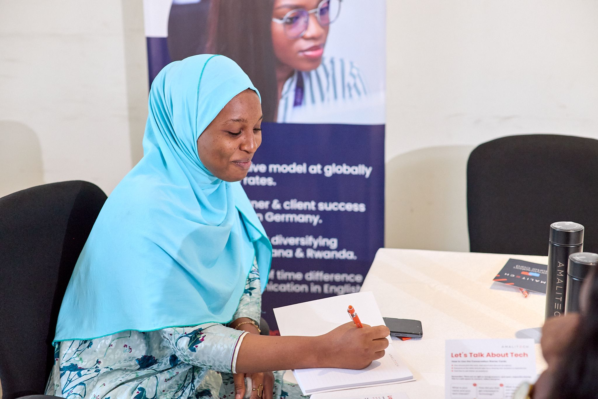 a young lady writing something amidst smiles
