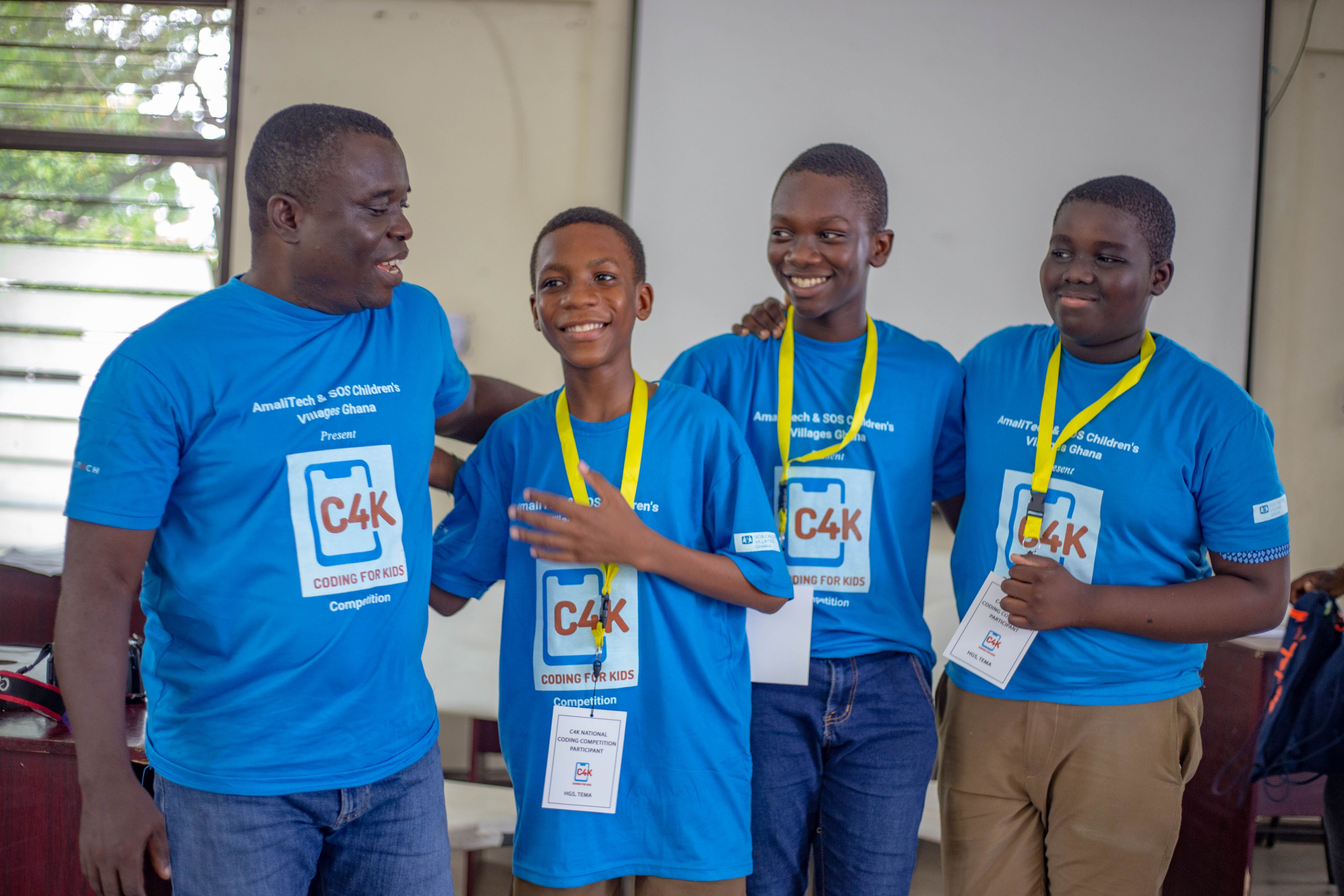A group of four standing next to each other, wearing medals and smiling. They just won an award.