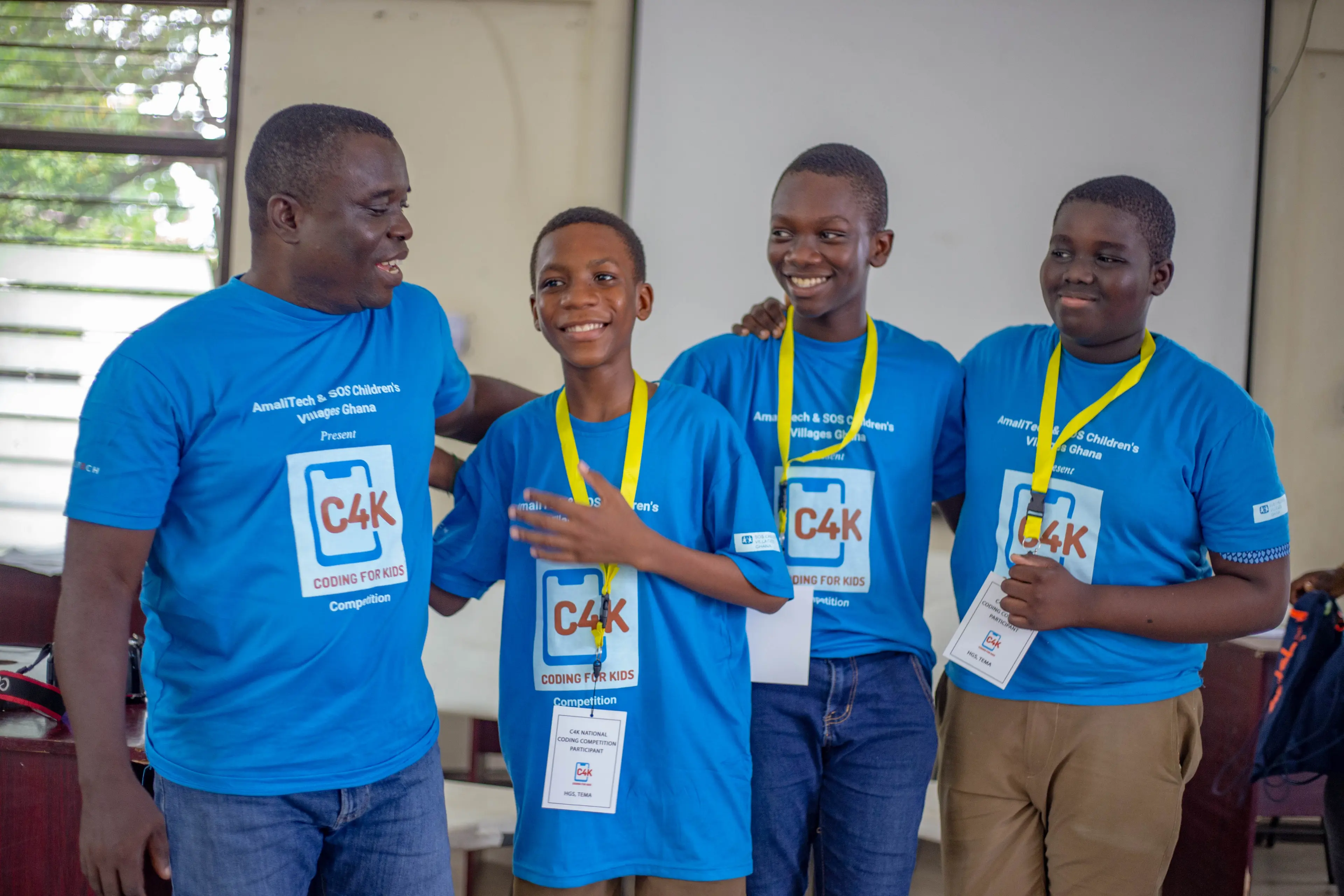 A group of four standing next to each other, wearing medals and smiling. They just won an award.