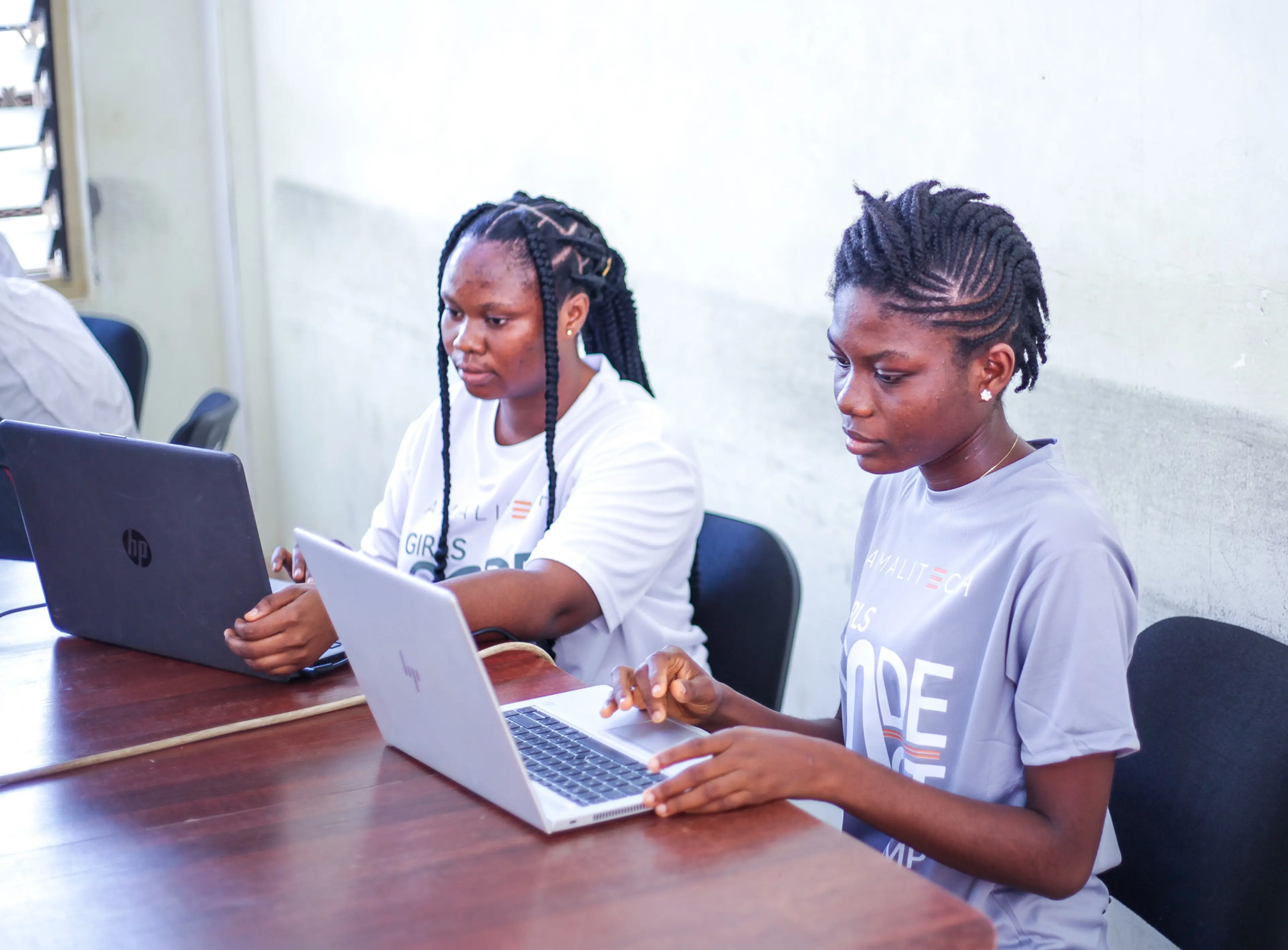 Two women sitting at their desks, working on their computers