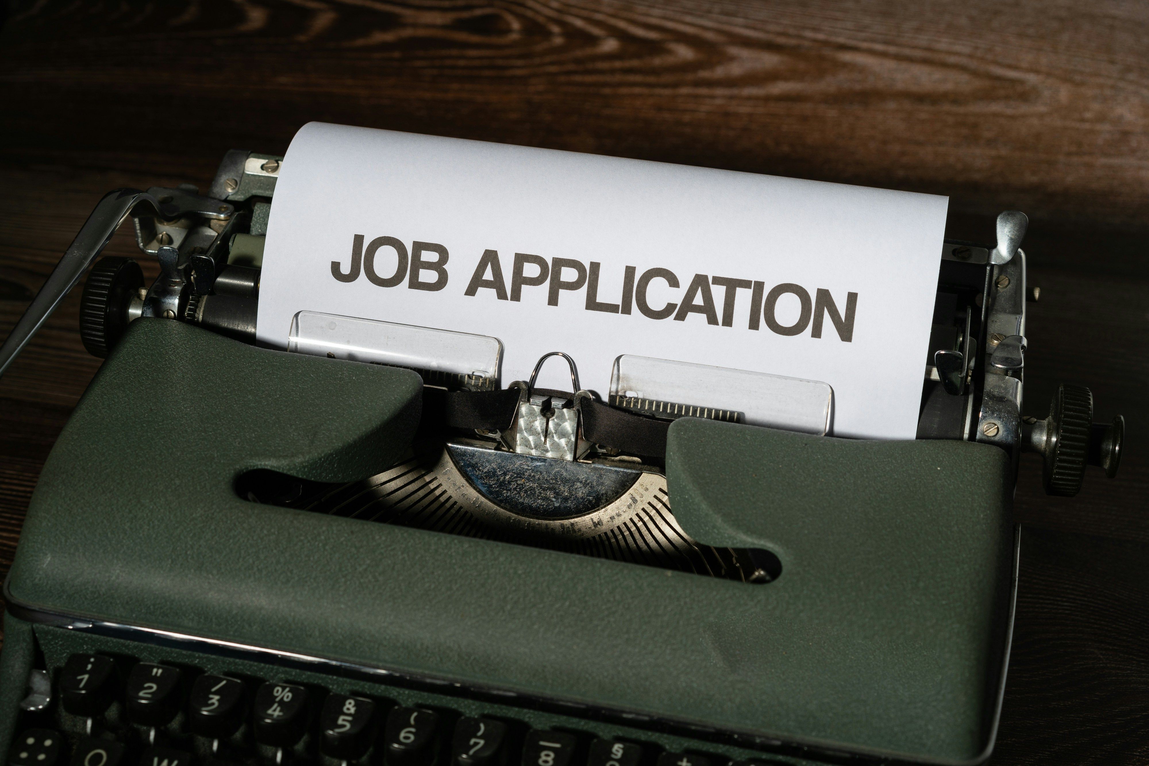 a sheet with job application written on it coming out of a printer