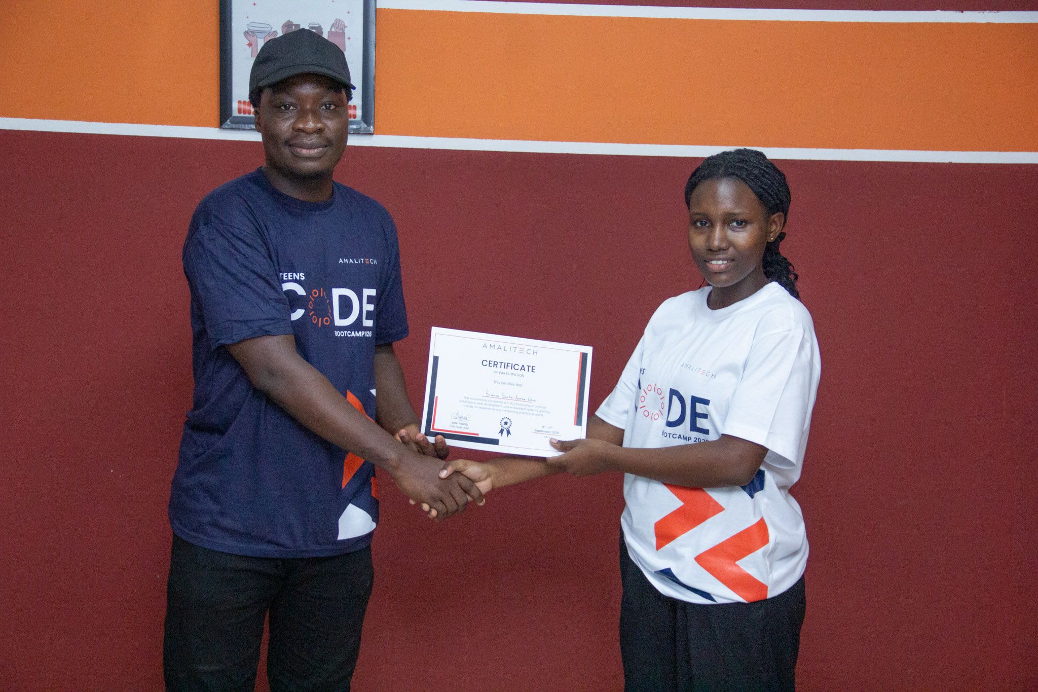 Trainer presents a certificate of participation to a teen at AmaliTech's Teens Code Bootcamp 2026 in Takoradi, Ghana.