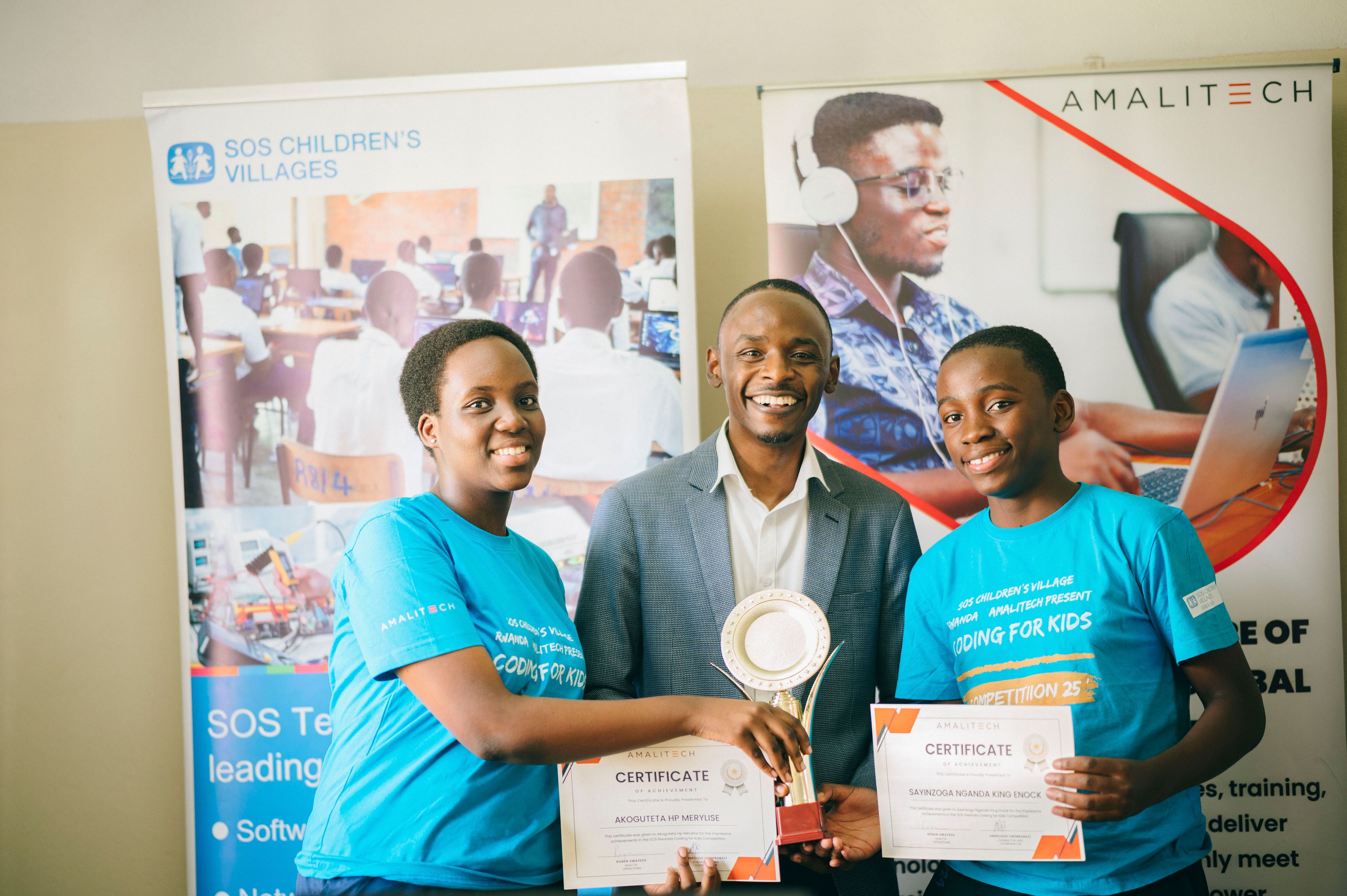 A group of two children and one adult holding up certificates and smiling