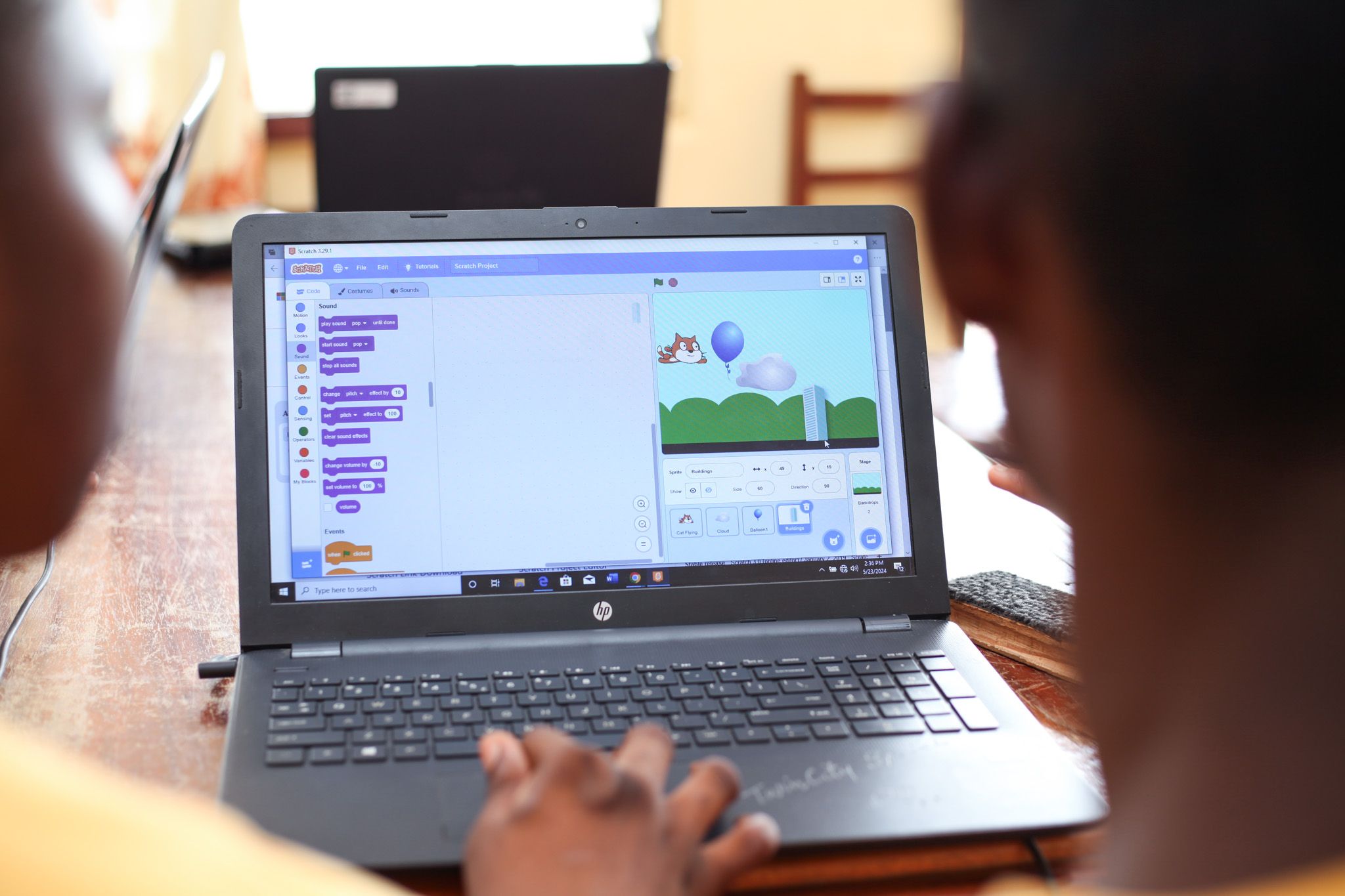Over the shoulder view of two children working on a computer