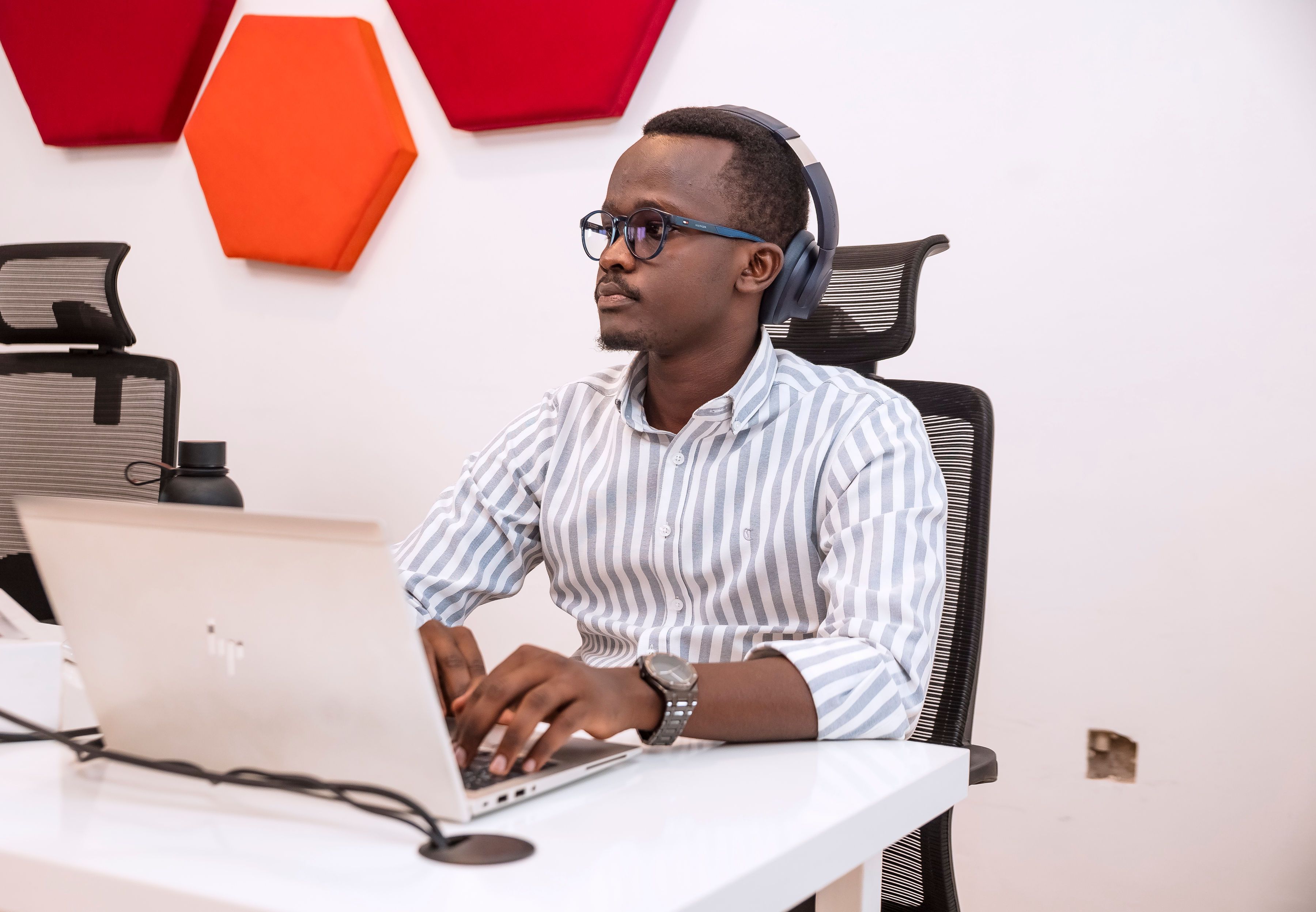 A man wearing headphones, working on his computer