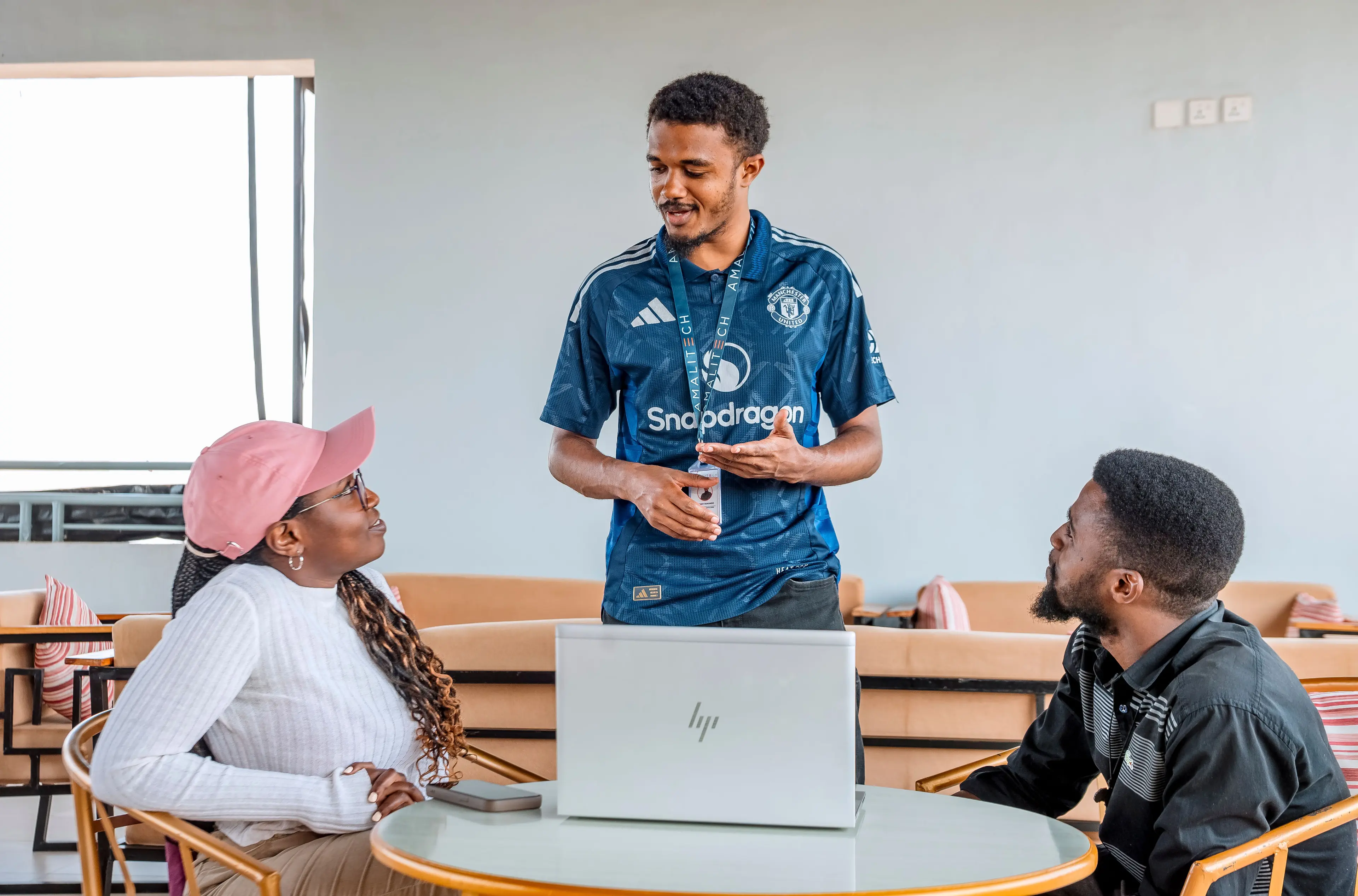 three people interacting, and watching a screen