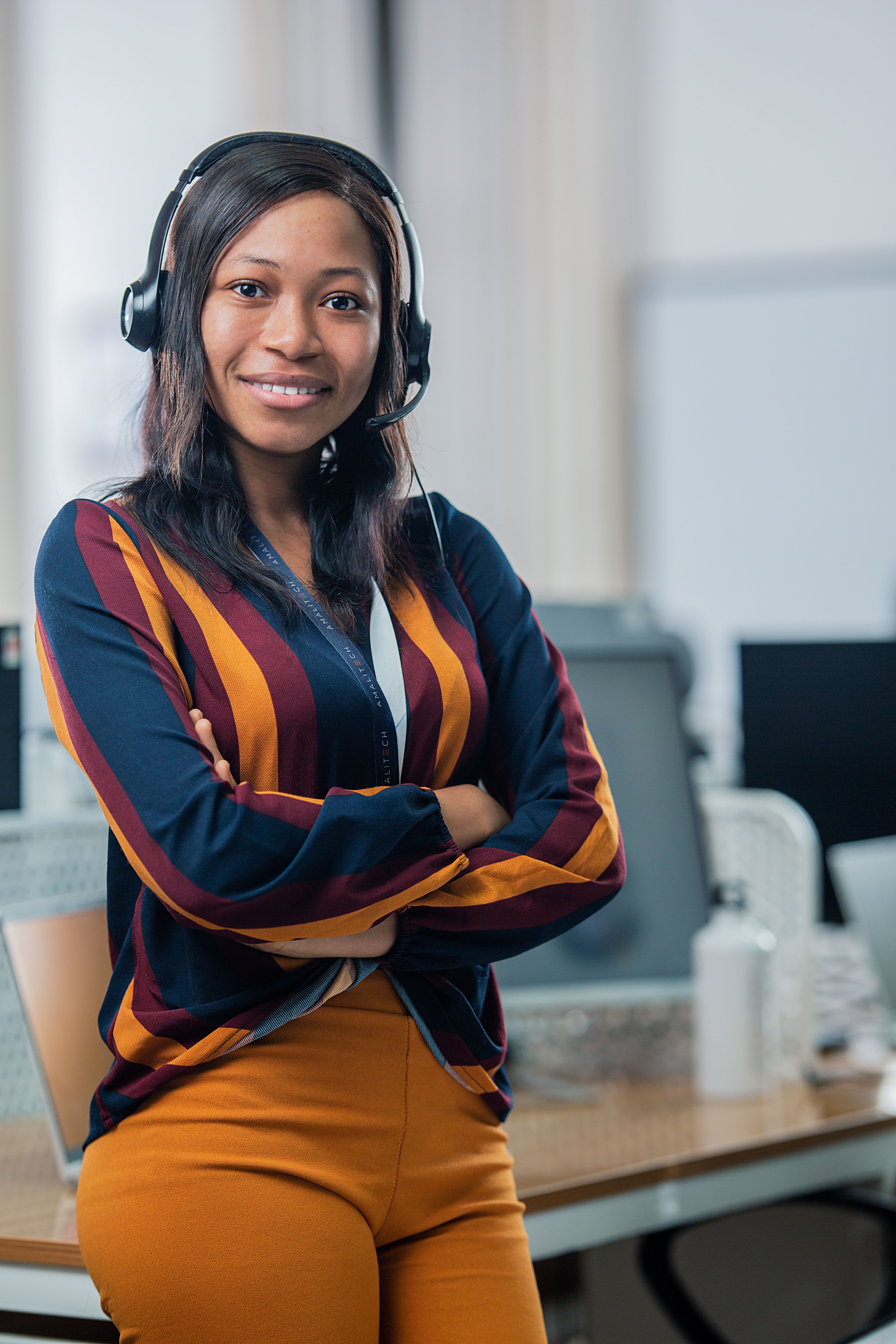 A women wearing a headset, smiling at the camera