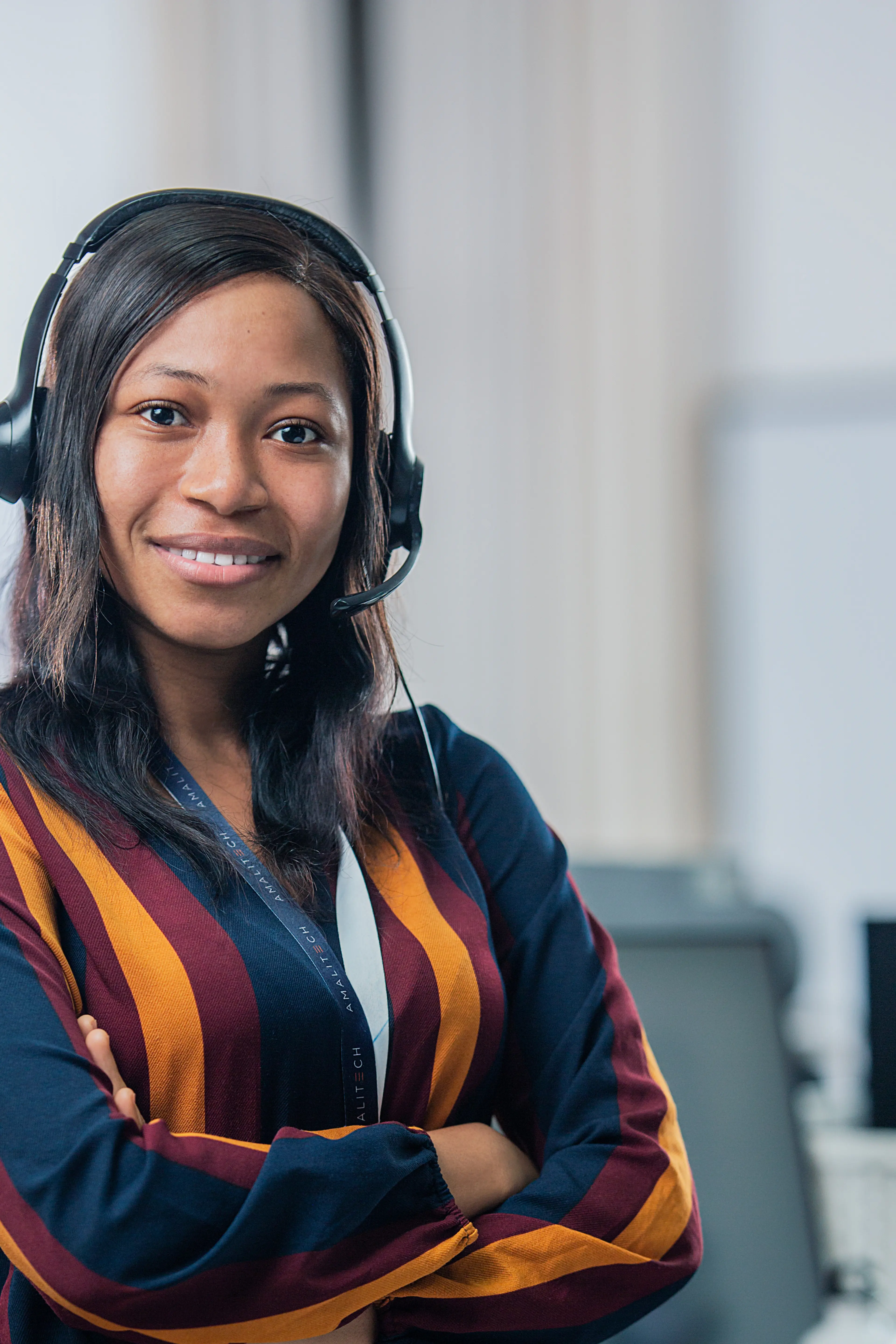A women wearing a headset, smiling at the camera
