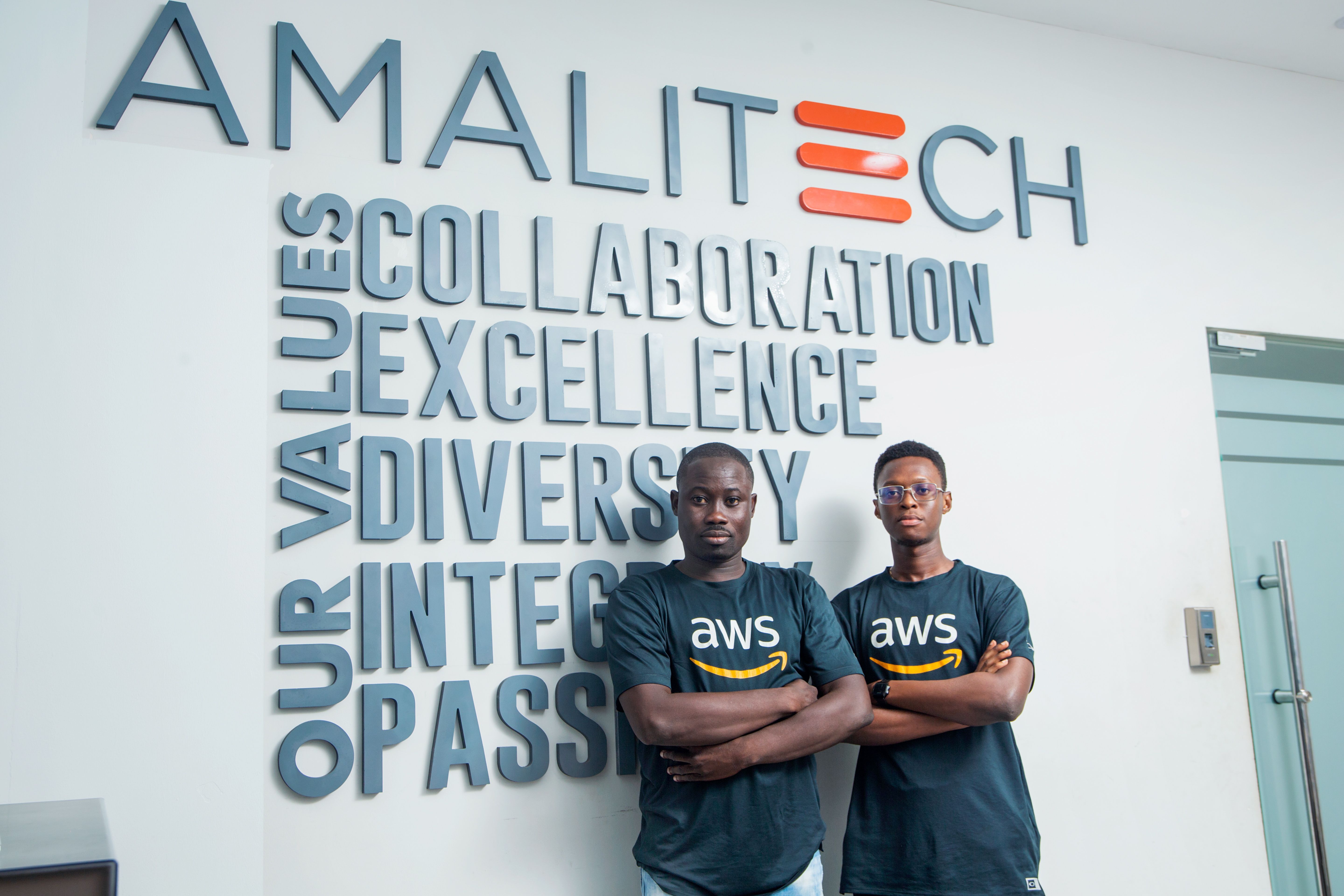Two young men in a black AWS customised tshirts with folded arms