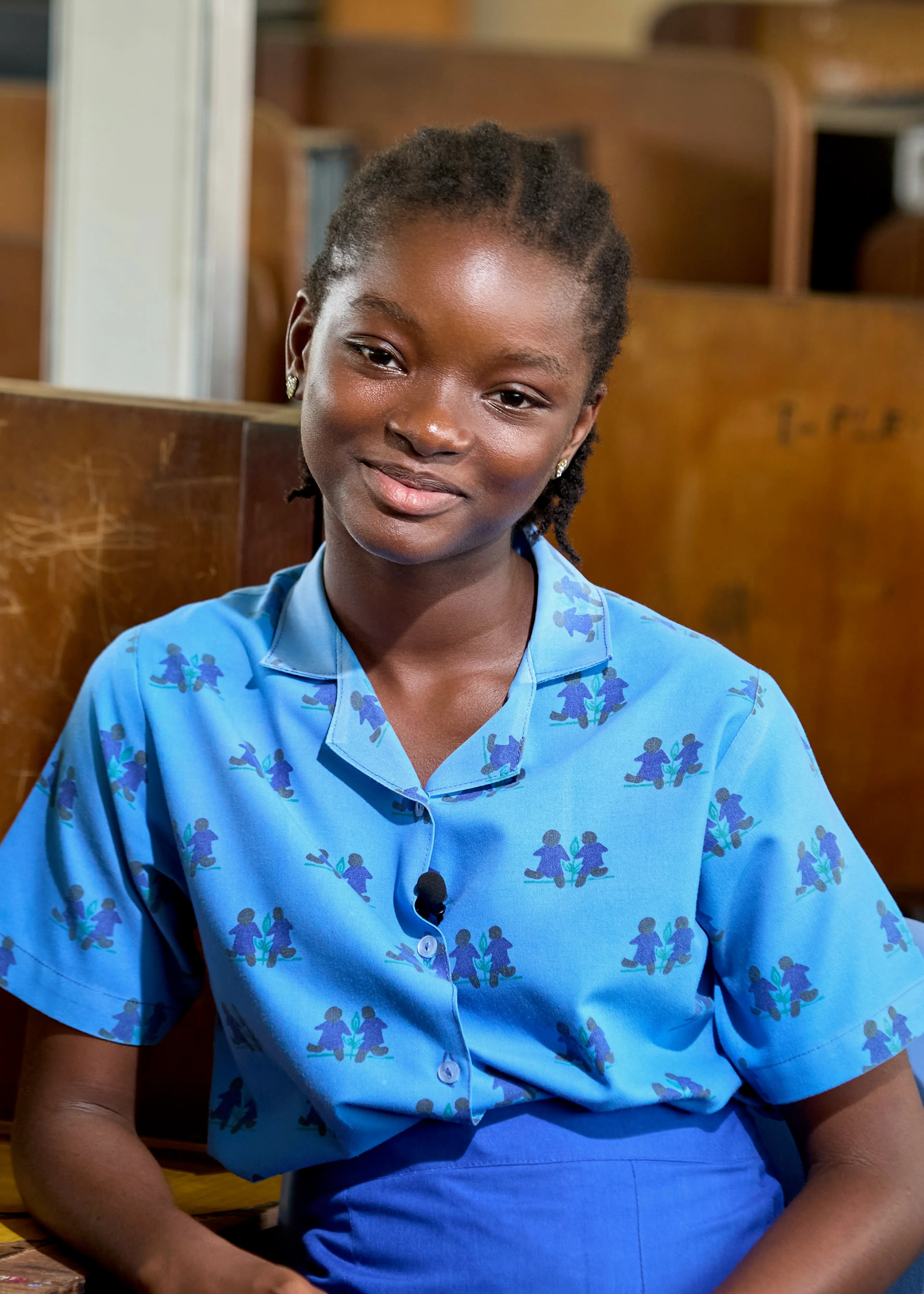 A young girl sitting on a chair and smiling at the camera