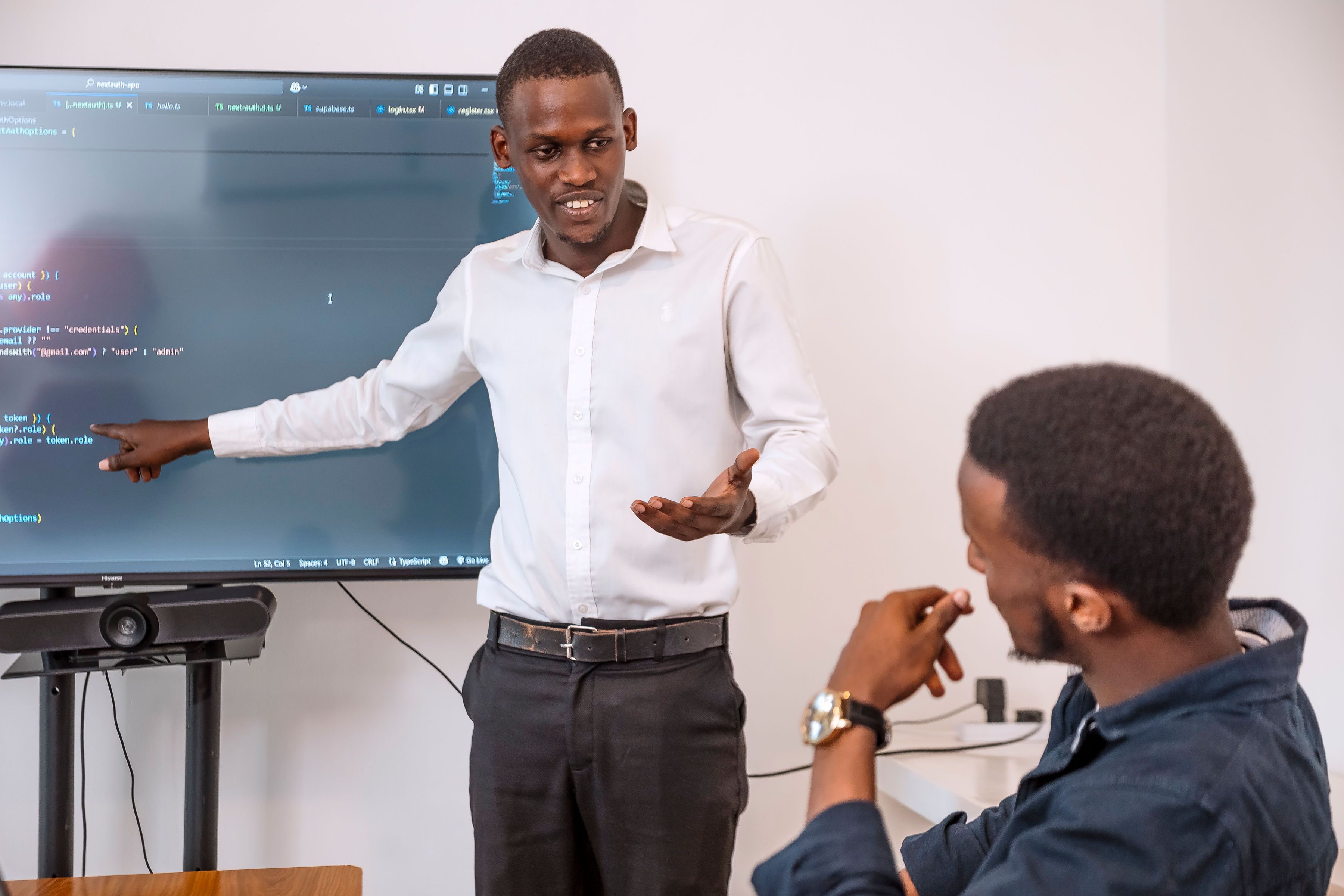 A man standing next to a screen, presenting.