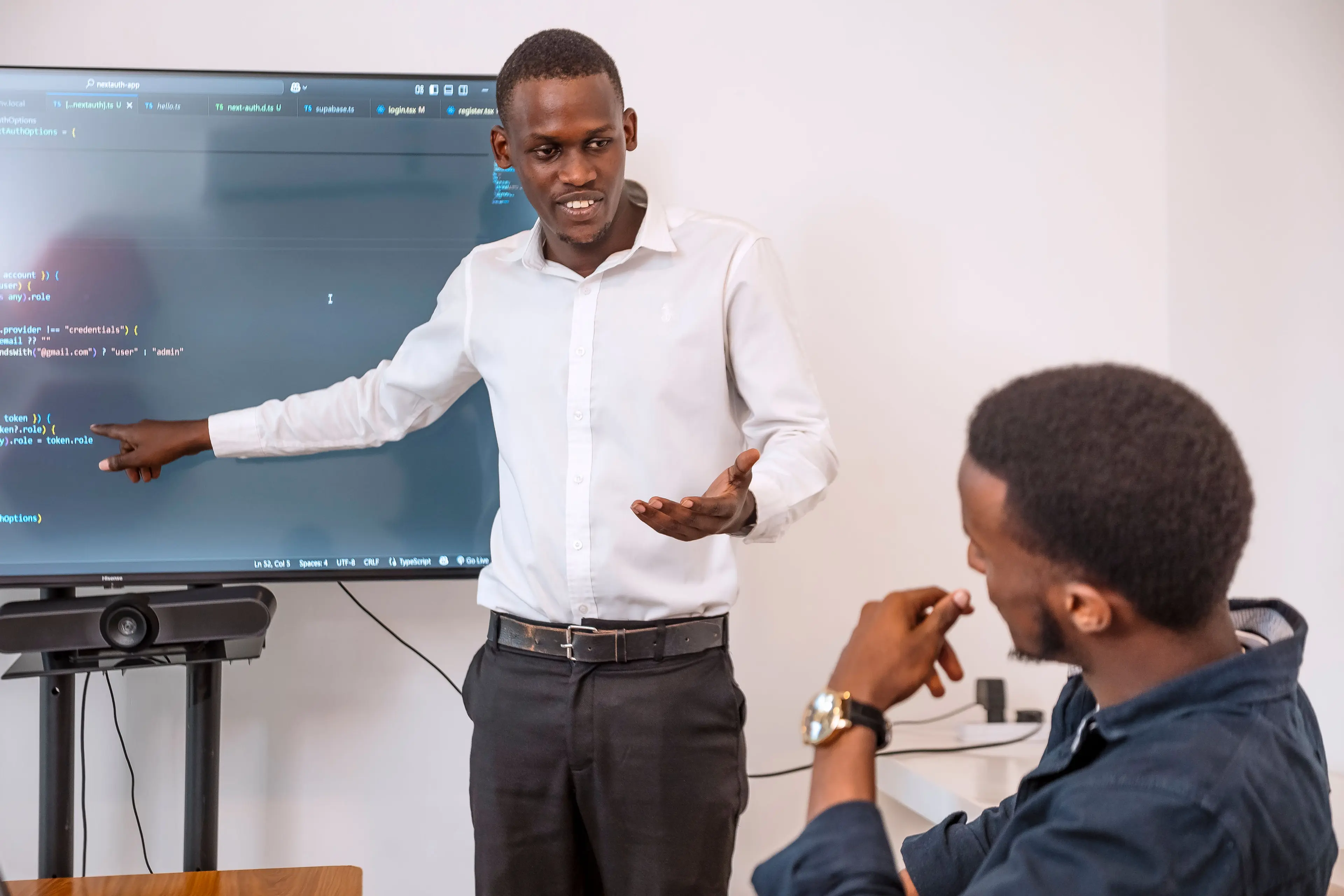 A man standing next to a screen, presenting.
