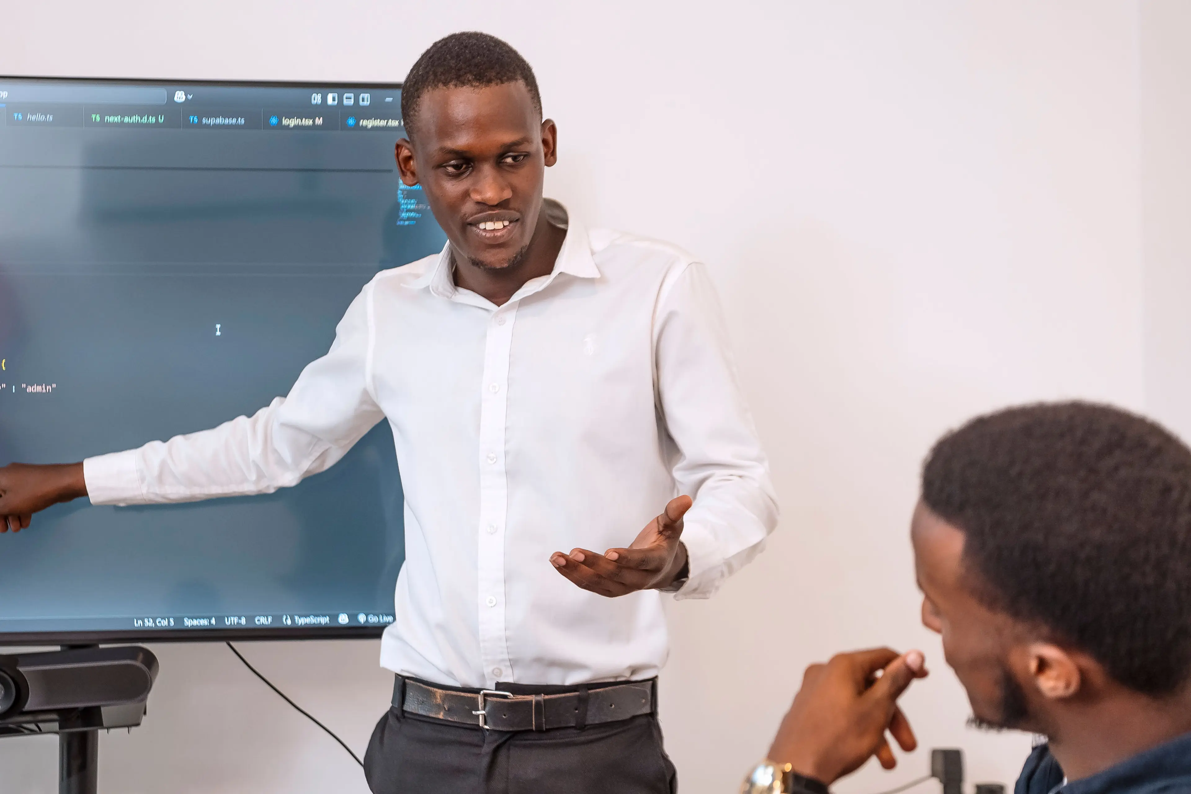 A man explaining content on a screen to another man