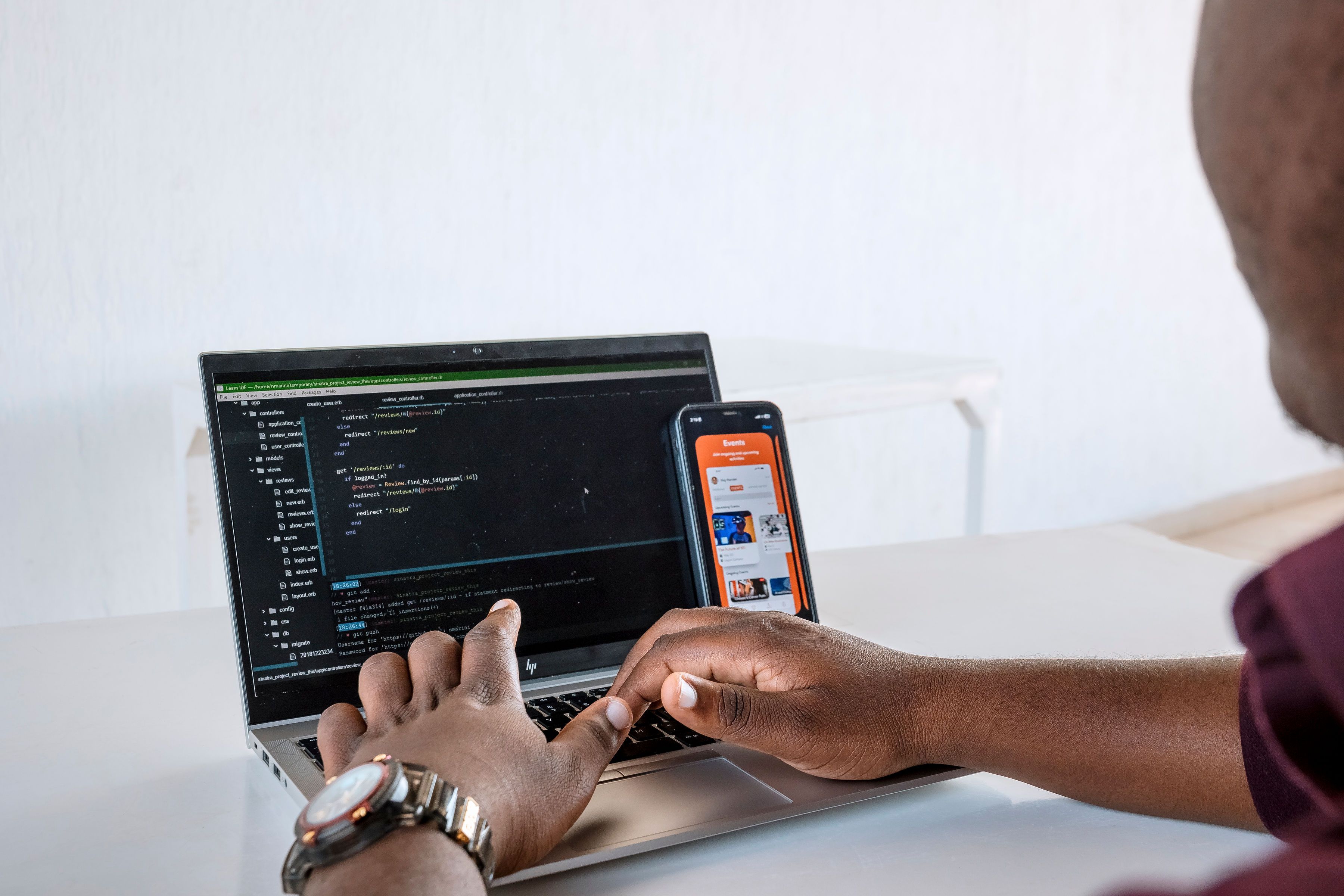 Hands on a keyboard with codes showing on the screen