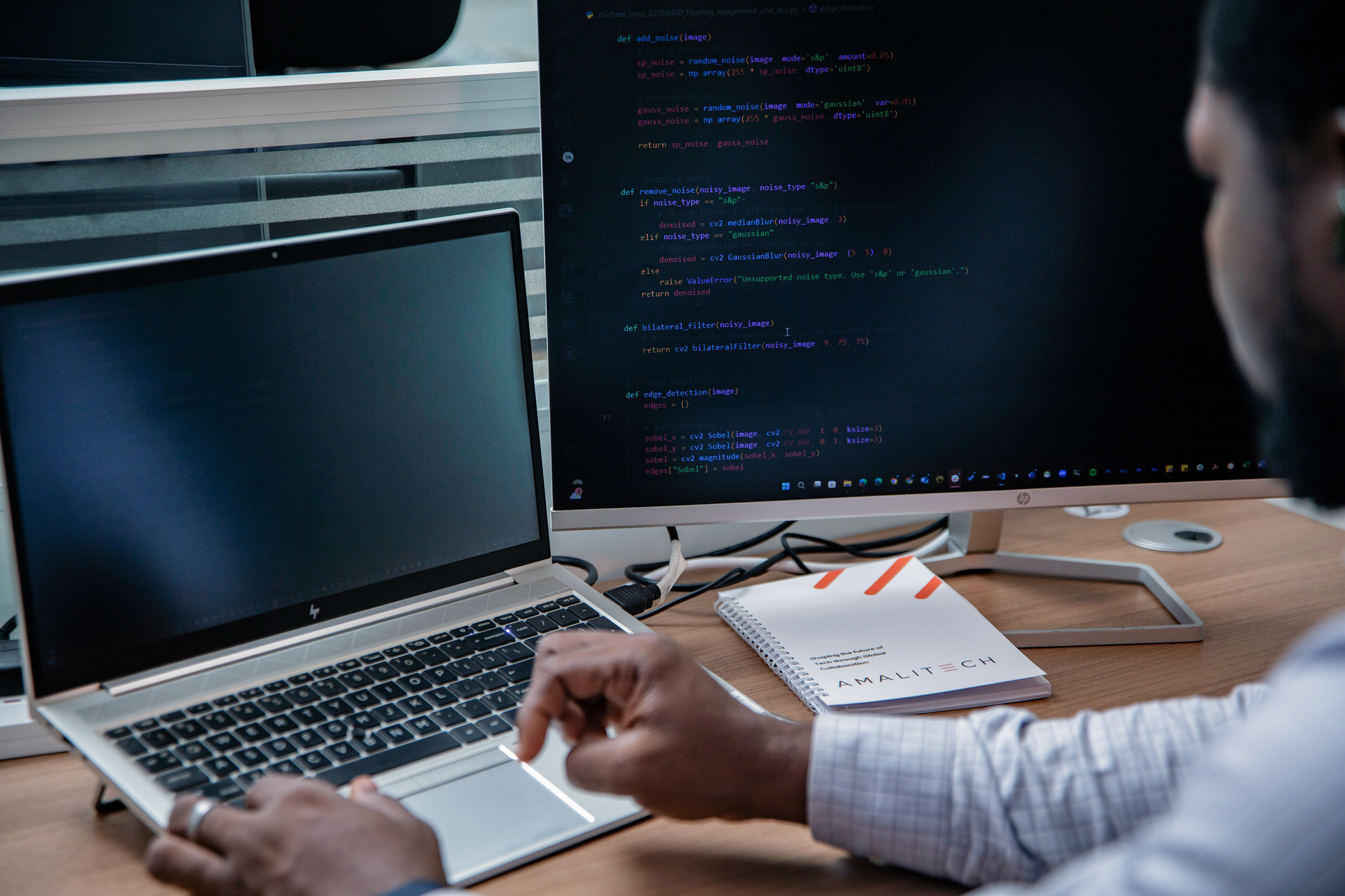 A man sitting at his desk, working on his laptop