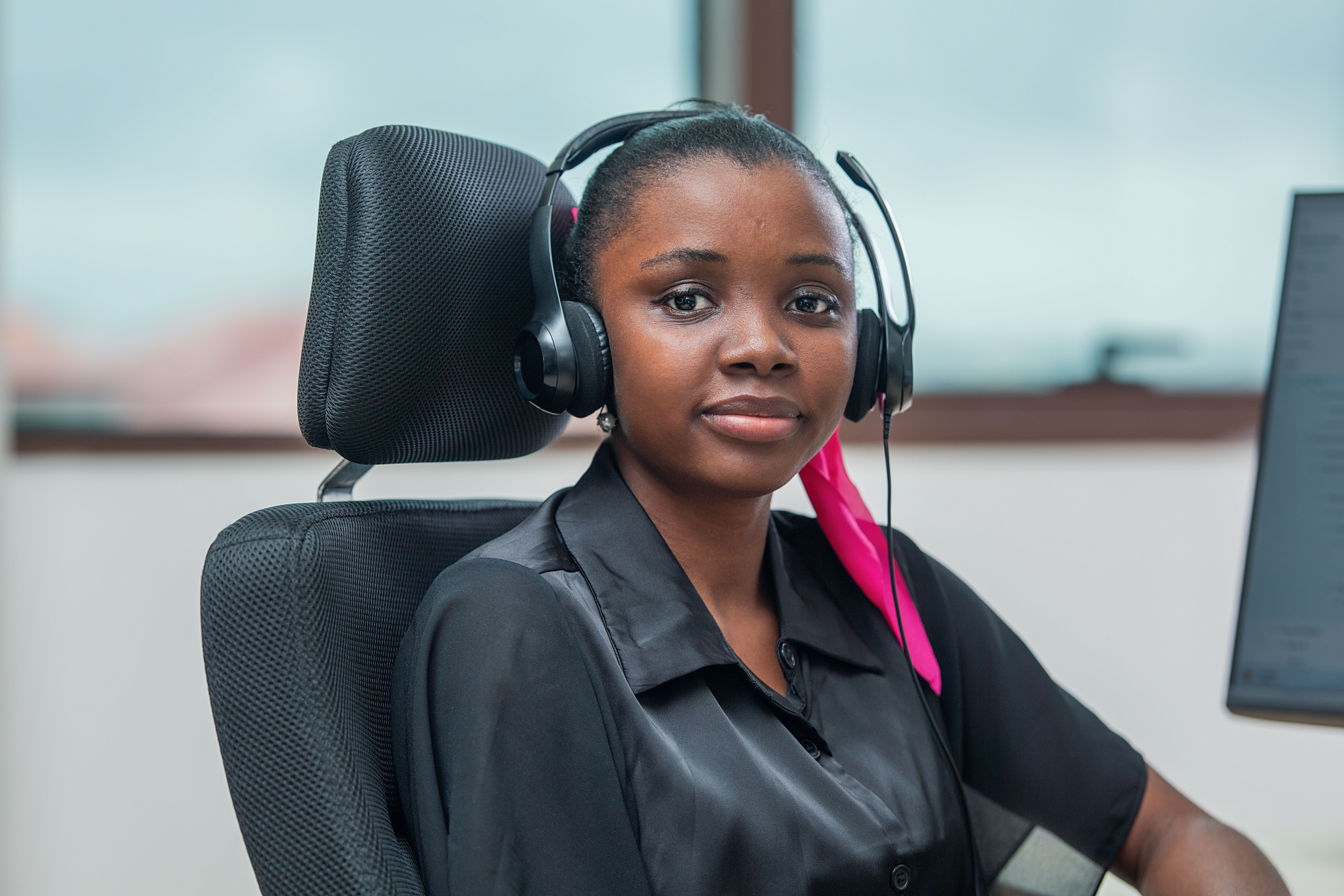 A women wearing a headset, looking at the camera