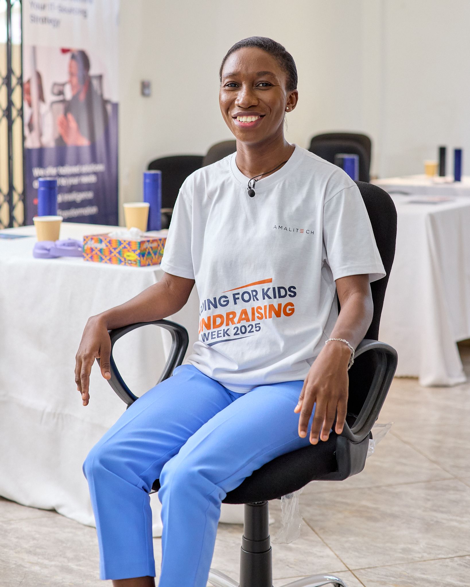 a woman sitting on a chair and smiling at the camera