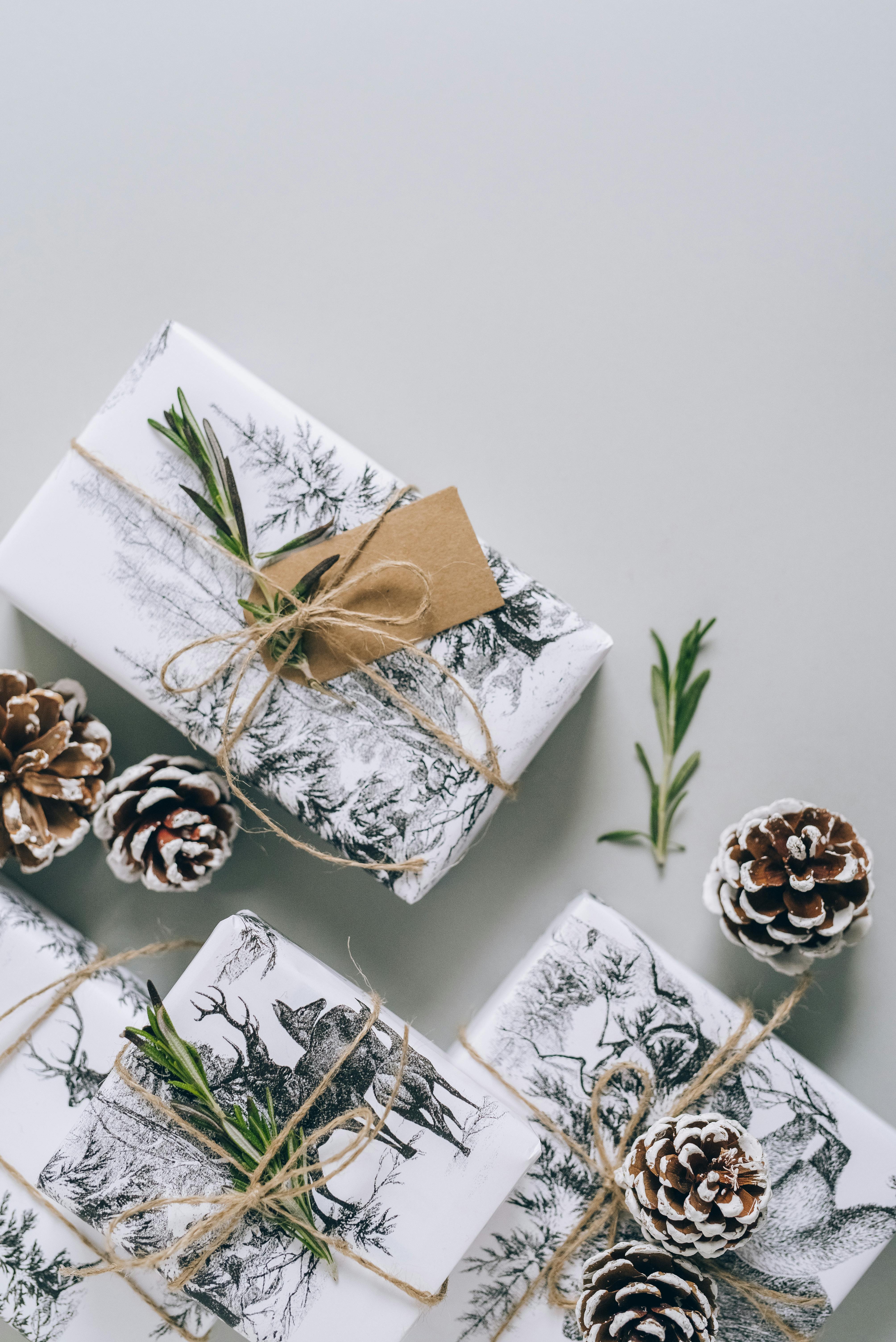 Picture of gifts wrapped in white paper with deer design and pinecones