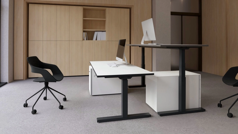Zwei 25-table Q nebeneinander, einer auf Sitzhöhe mit weißer Platte, einer höher gefahren mit lavagrauer Platte.