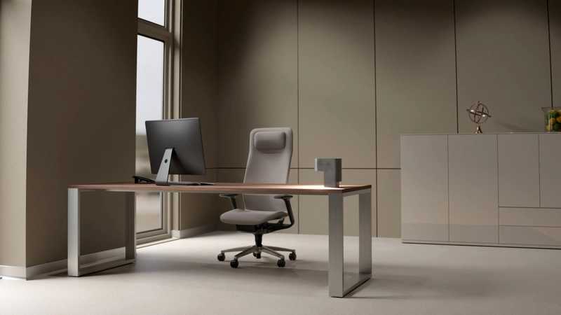 Quandos Schreibtisch mit Nussbaumplatte und Aluminiumrahmen, darauf ein Monitor, dahinter ein Sideboard.