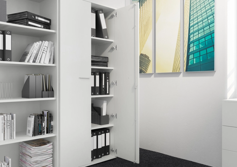 Weißer Flügeltürenschrank mit einer geöffneten Tür neben einem offenen Regal mit Ordnern und Büchern.