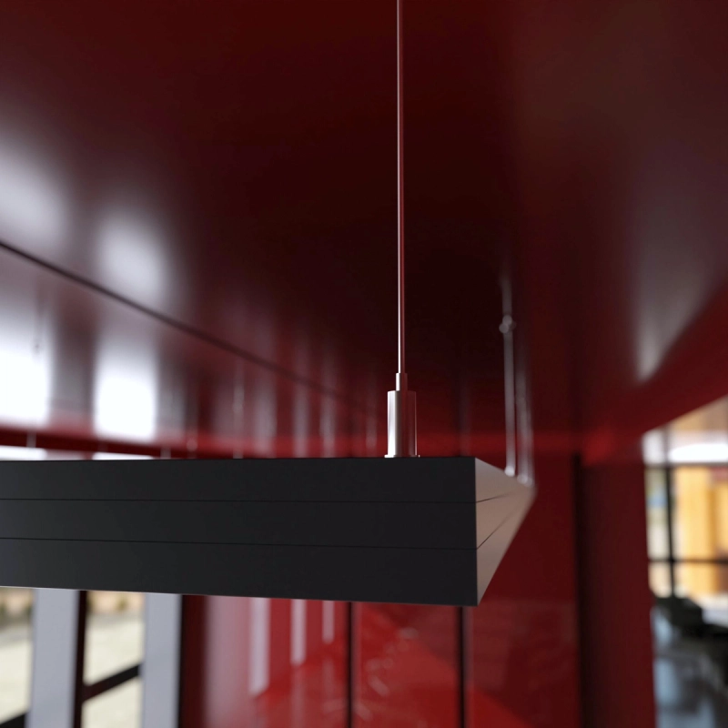 Nahansicht der Ecke eines dunklen Akustik-Deckenpaneels mit schwarzem Profilrahmen und aufgesetzter Seilklemme.