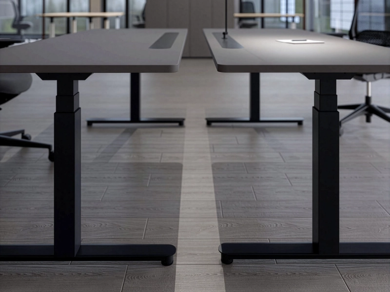 Zwei gegenüberstehende 25-table R Schreibtische von Klain mit dunklem Gestell, abgerundeten Tischplattenecken und elegant geformten Fußauslegern in einem modernen Büro.