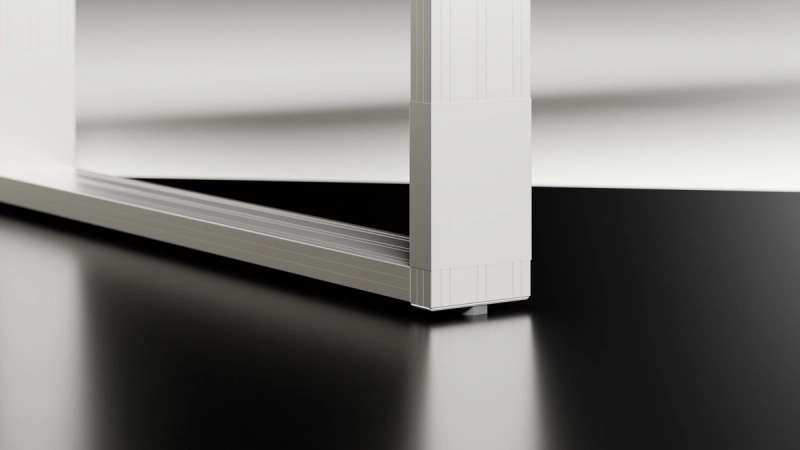 Bodennahe Detailaufnahme des Aluminiumrahmens eines Quandos Schreibtischs mit eingelassenem Gleiter.