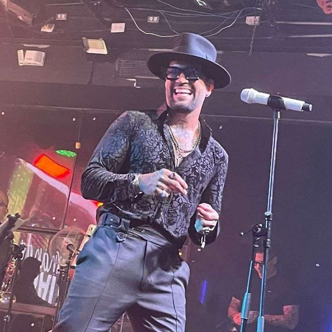 Cantante con sombrero negro actuando en vivo