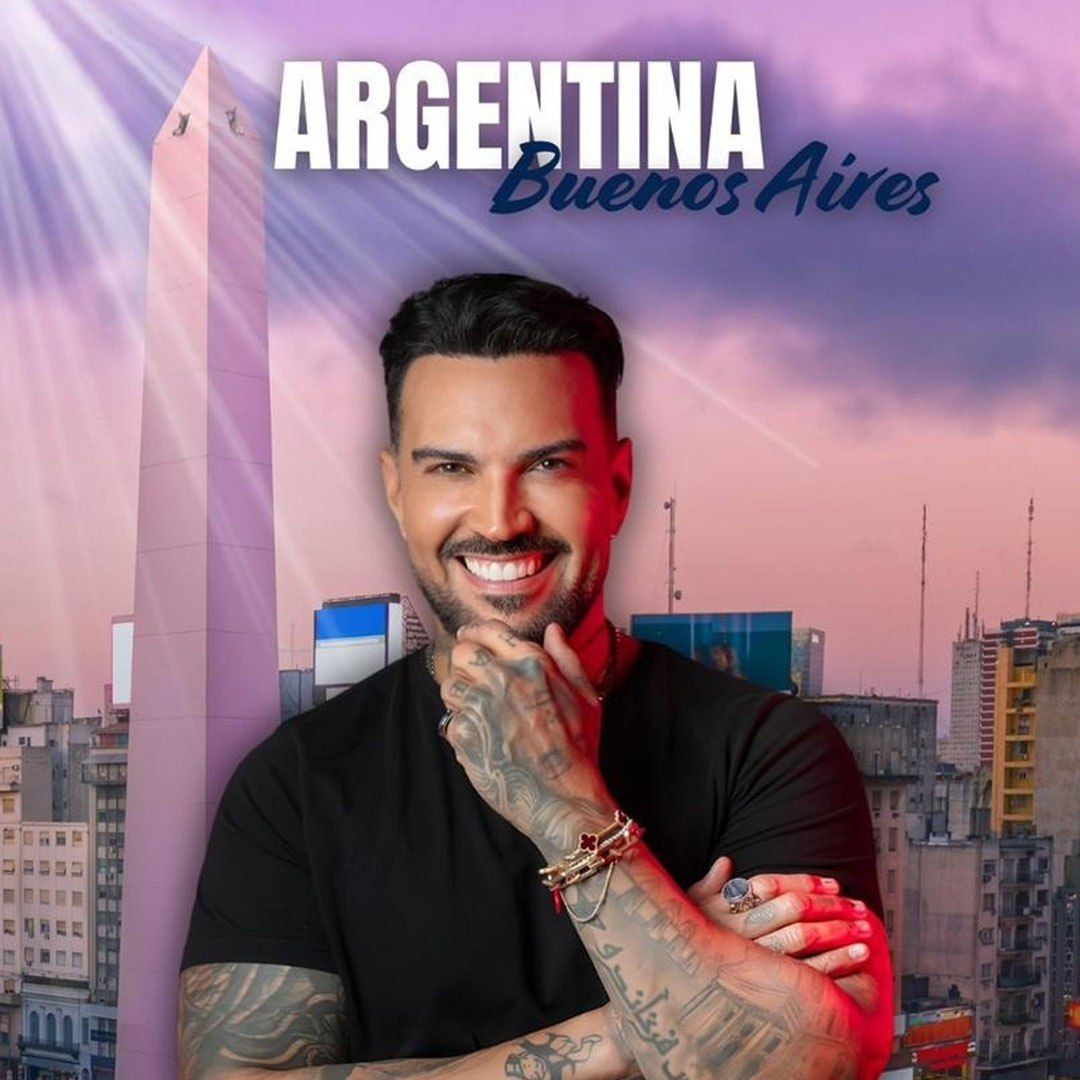 Cantante de blanco y anteojos sosteniendo un micrófono