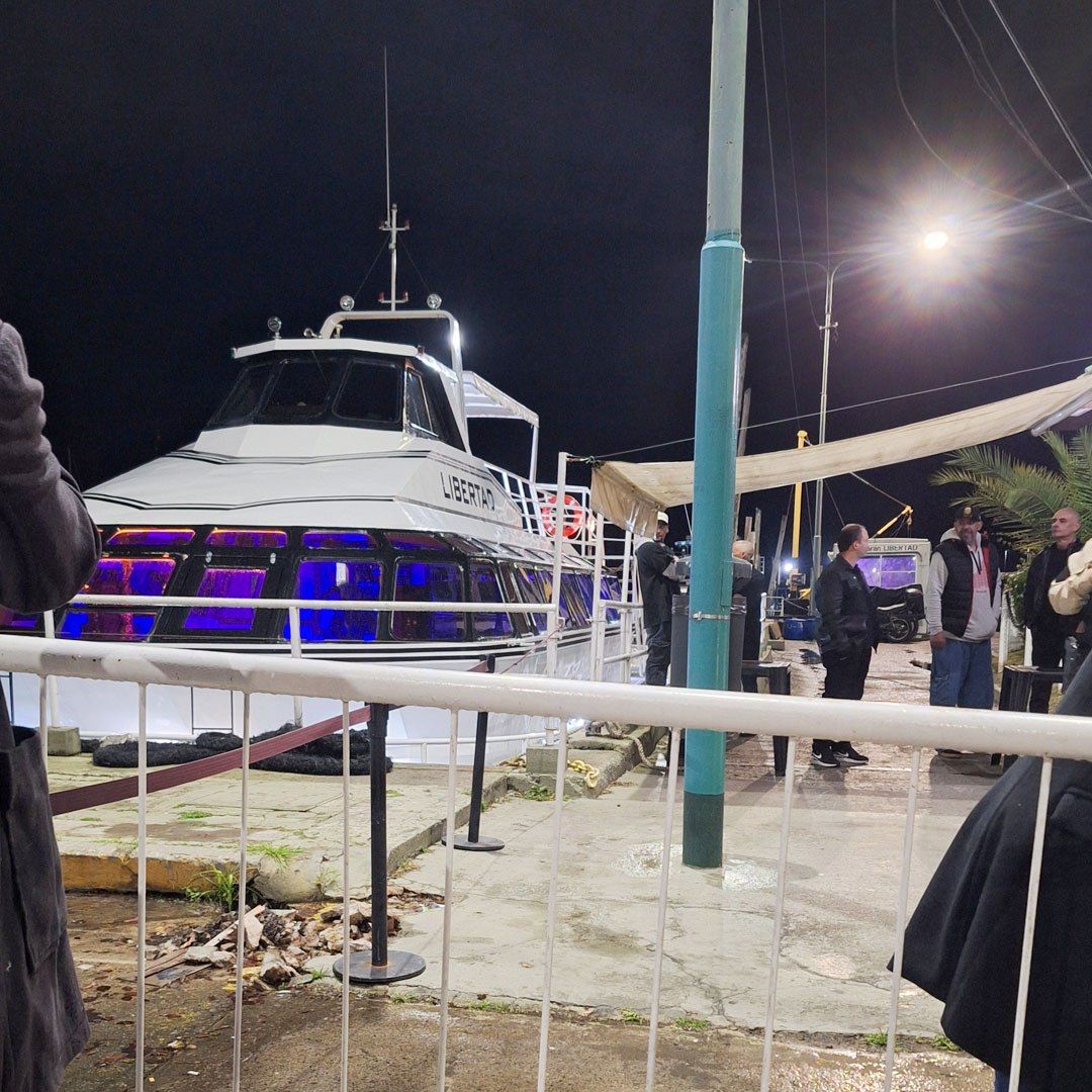Catamarán blanco atracado de noche con iluminación azul