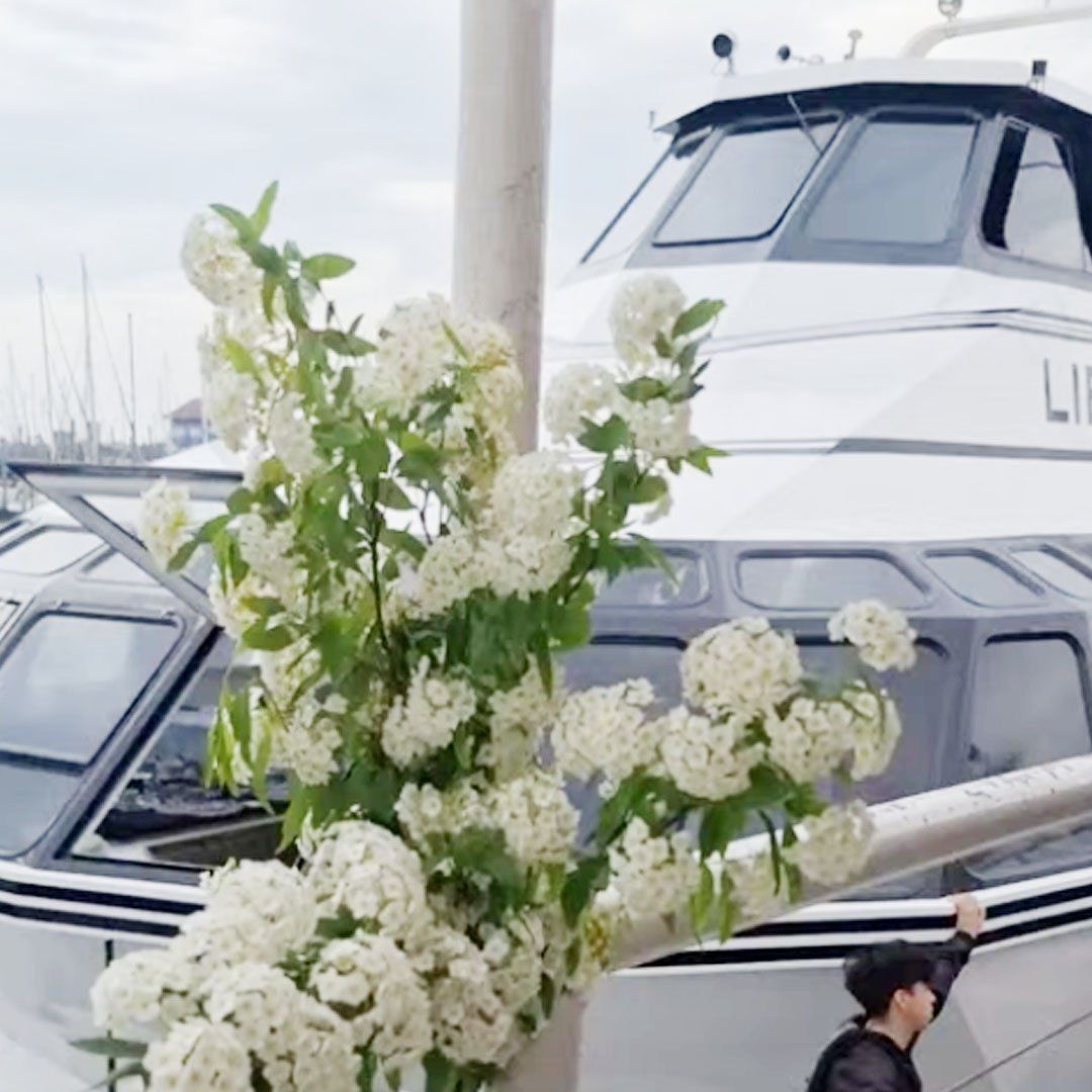 Flores blancas y catamarán atracado detrás