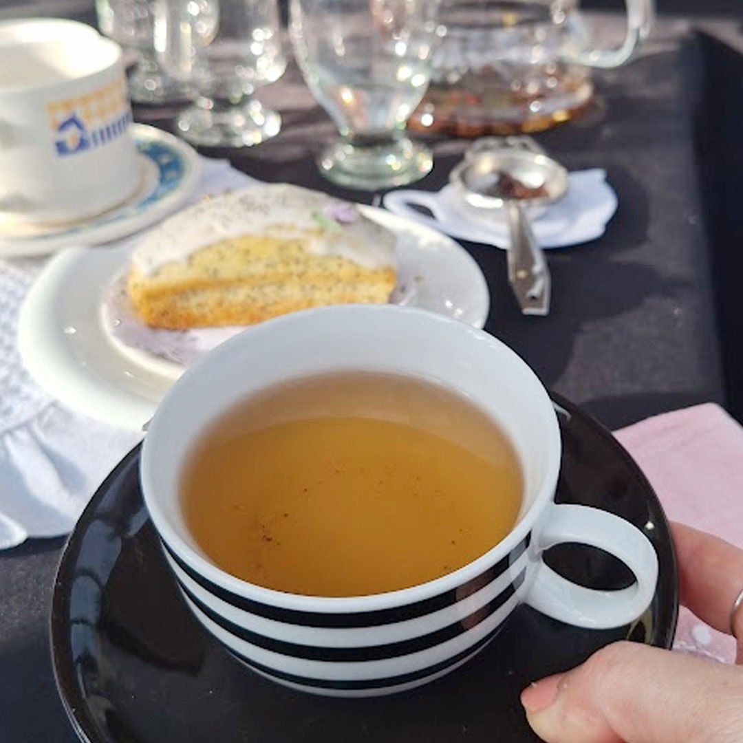 Mujer con taza de té mirando por la ventana del barco hacia el río