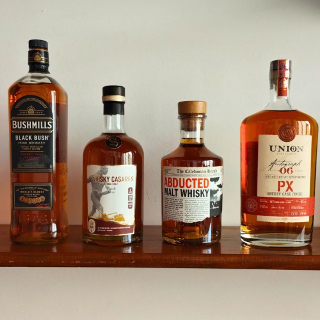 Cuatro botellas de whisky sobre un estante