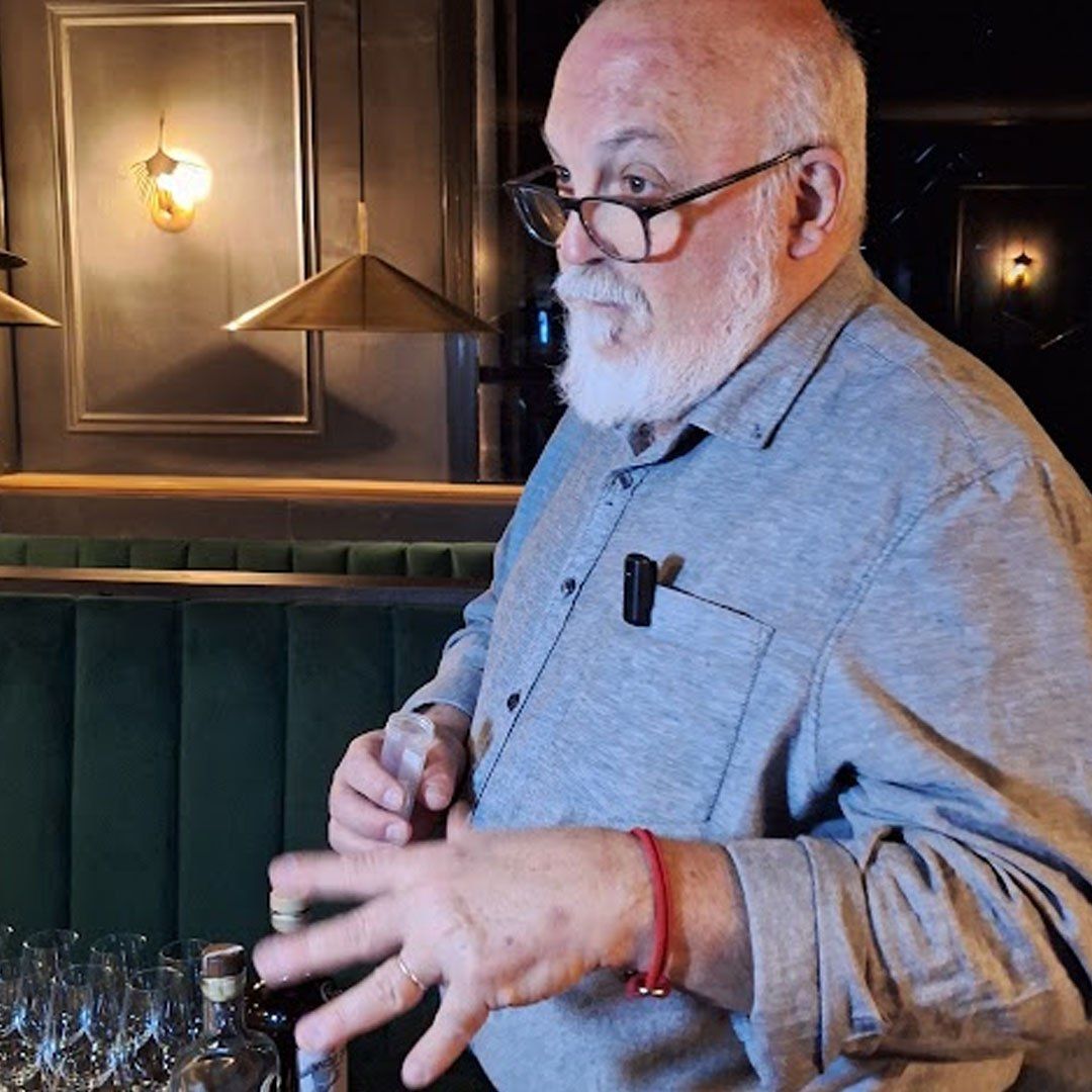 Hombre explicando la cata junto a botellas y copas