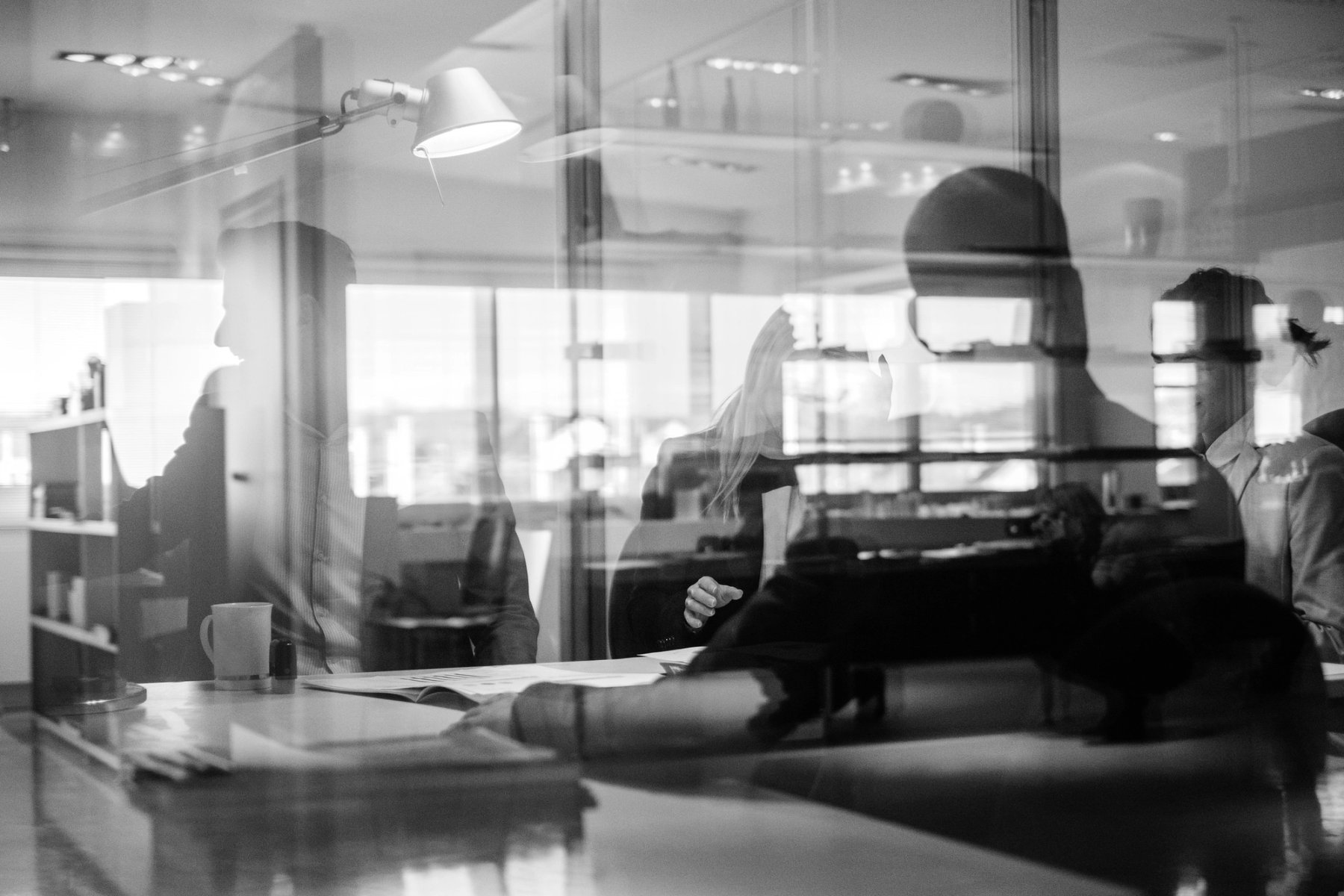 Office workspace with silhouettes reflected in glass