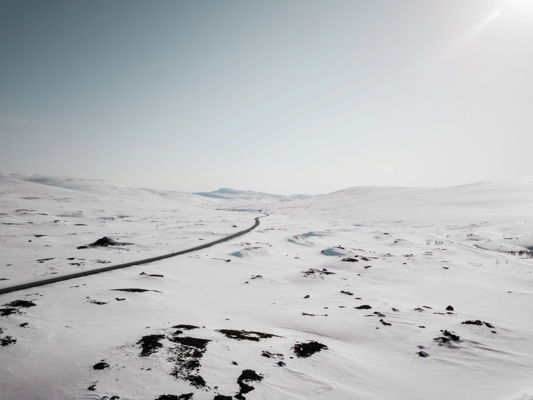 Road cutting through winter-covered mountain ranges