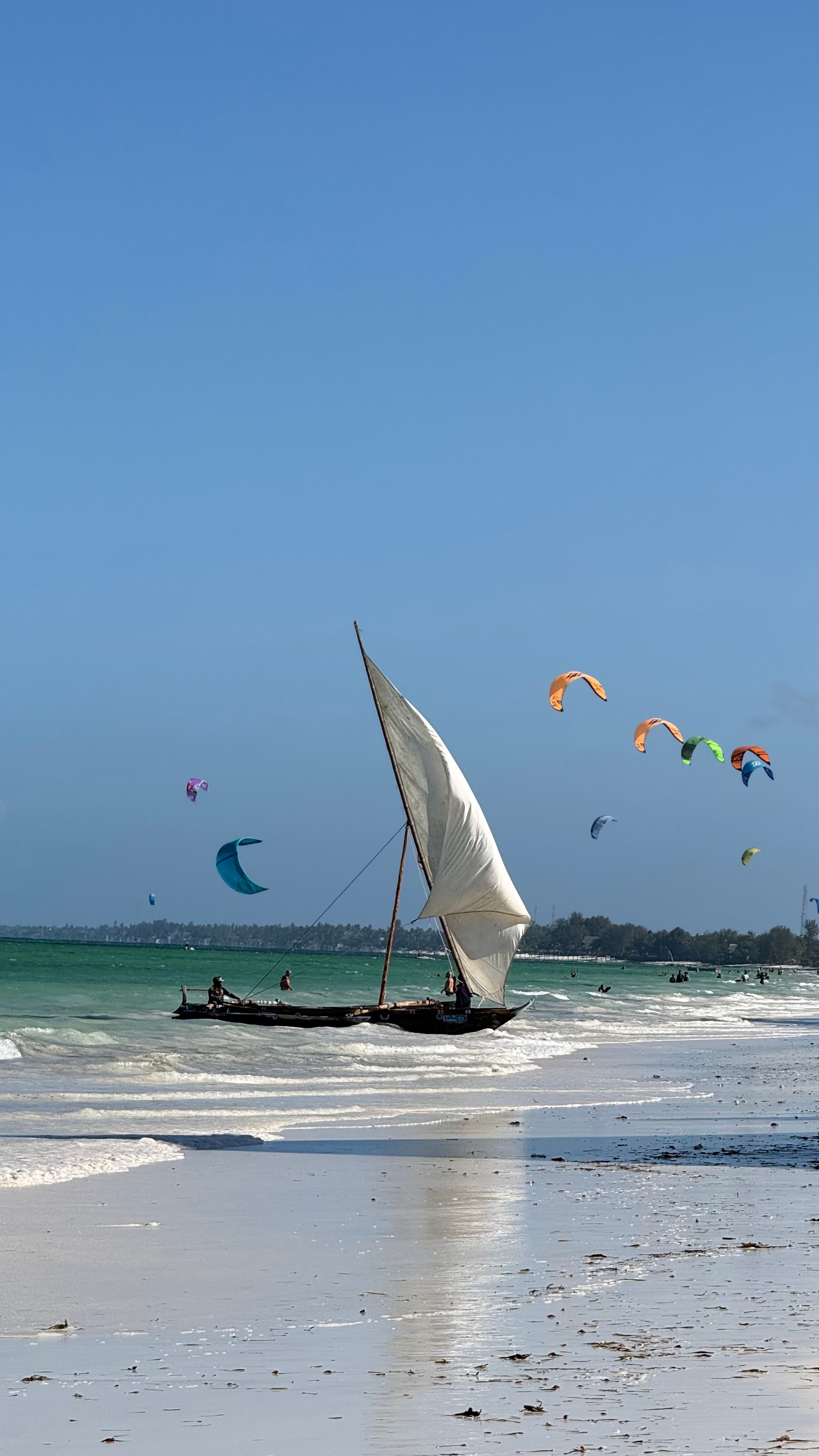 Vela de dhow com kitesurfistas ao fundo, em Paje.