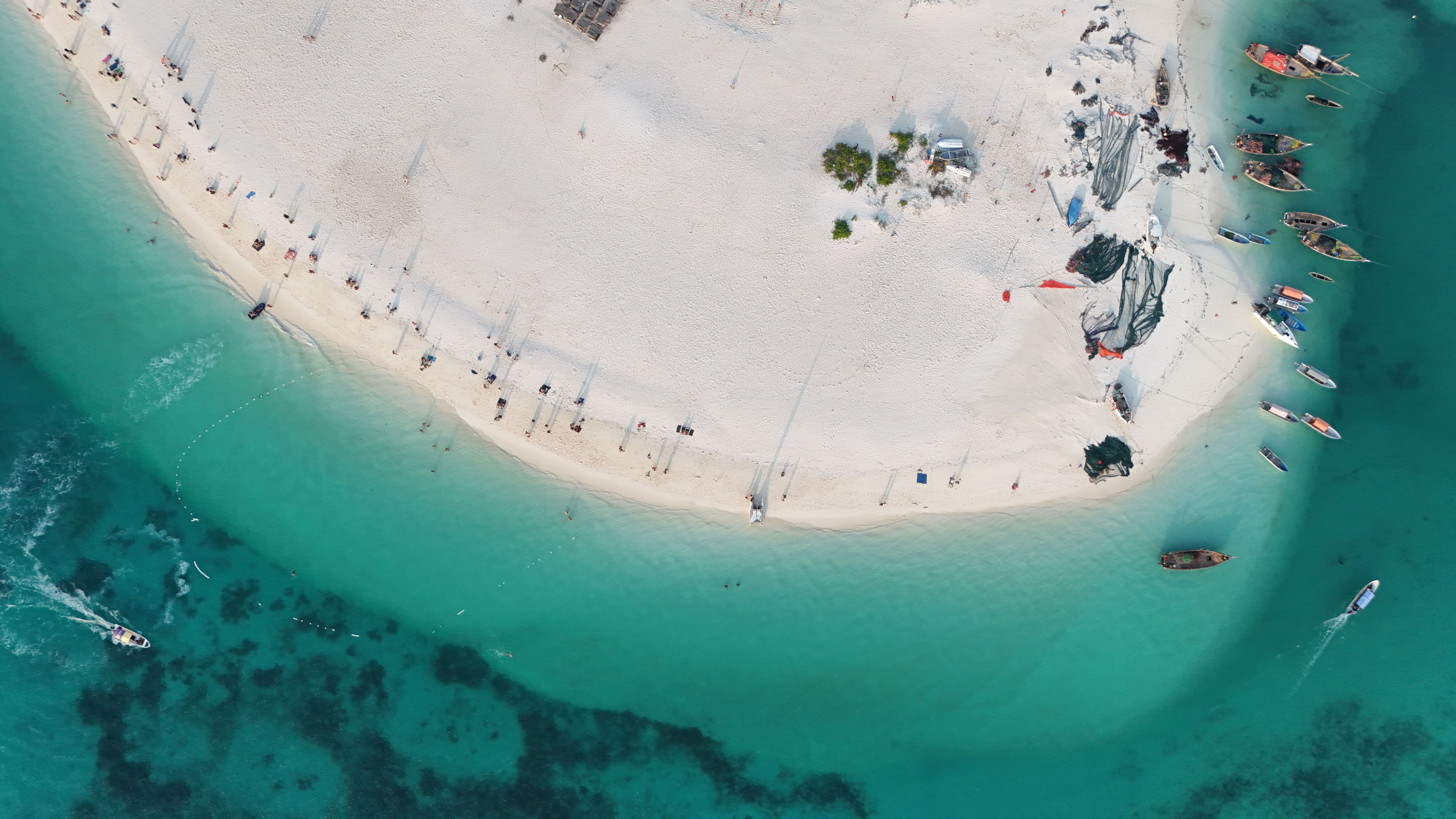 Banco de areia branco no meio do mar turquesa, visto do ar.