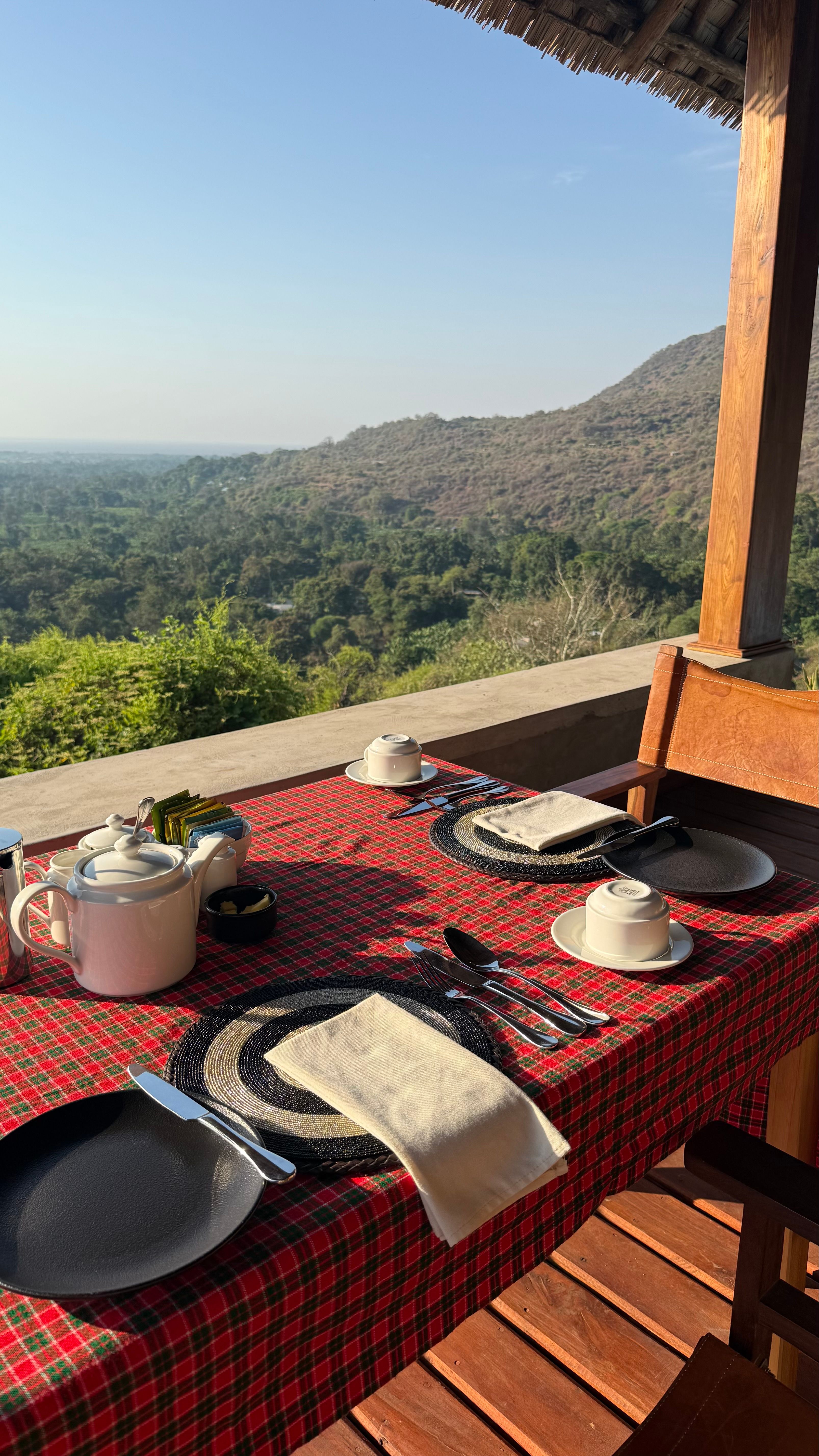 Mesa de pequeno-almoço no safari, toalha vermelha e vista aberta.