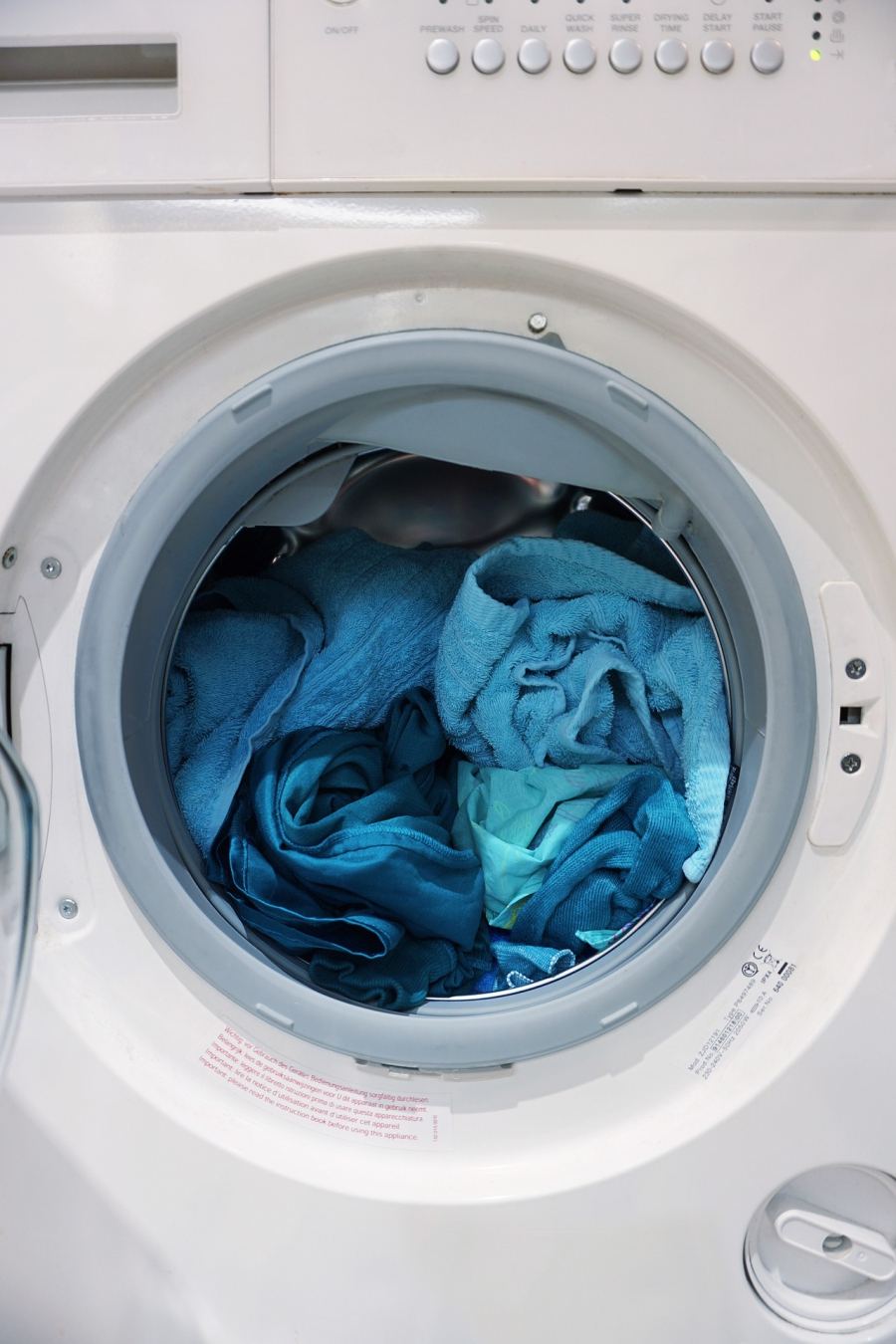 Blue laundry inside a front-loading washing machine