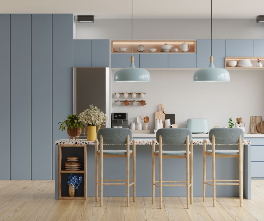 Tidy blue kitchen with pendant lights over a breakfast bar